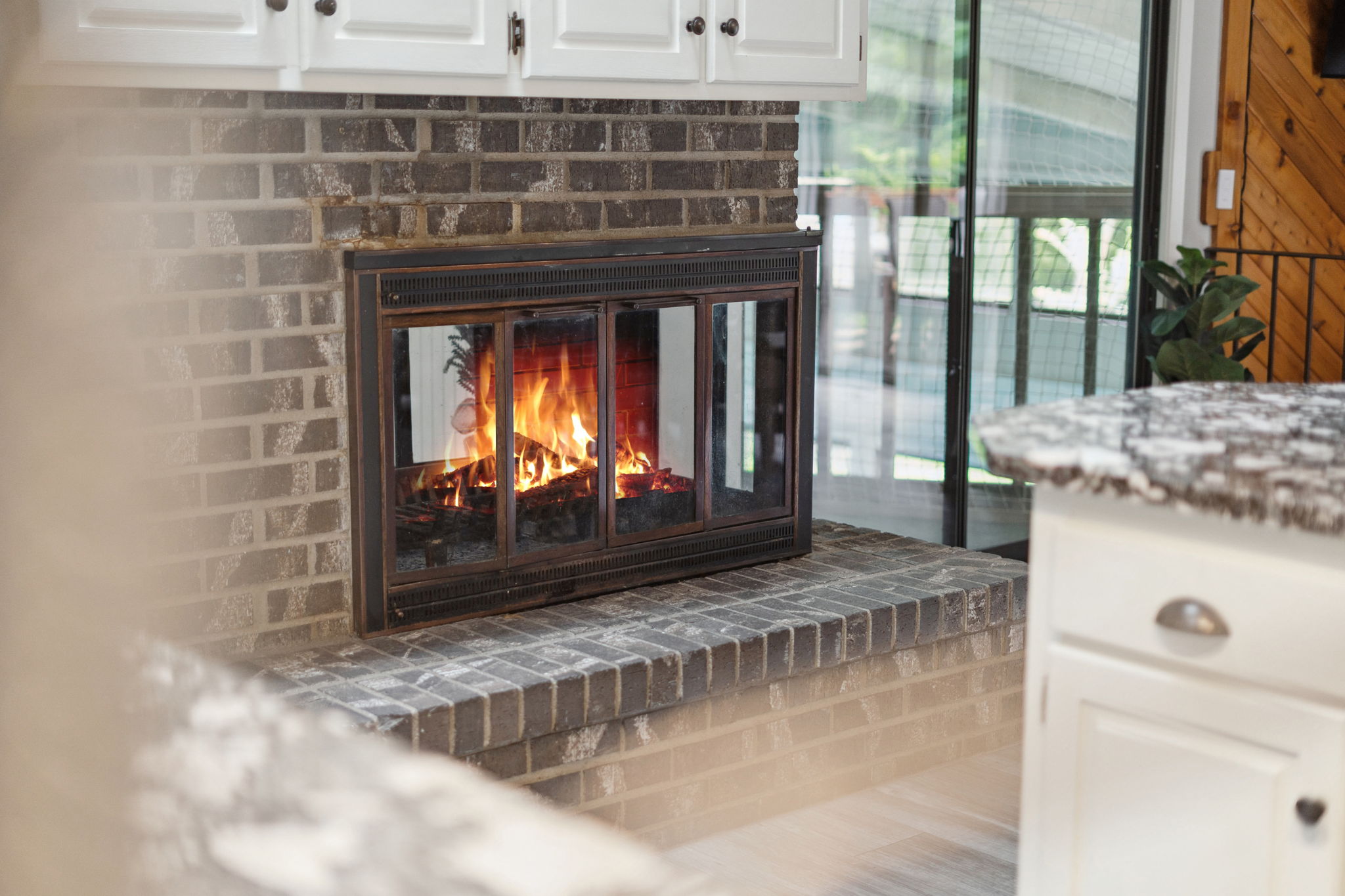 An inviting fireplace within a modern kitchen, featuring a warm flame and stylish design.