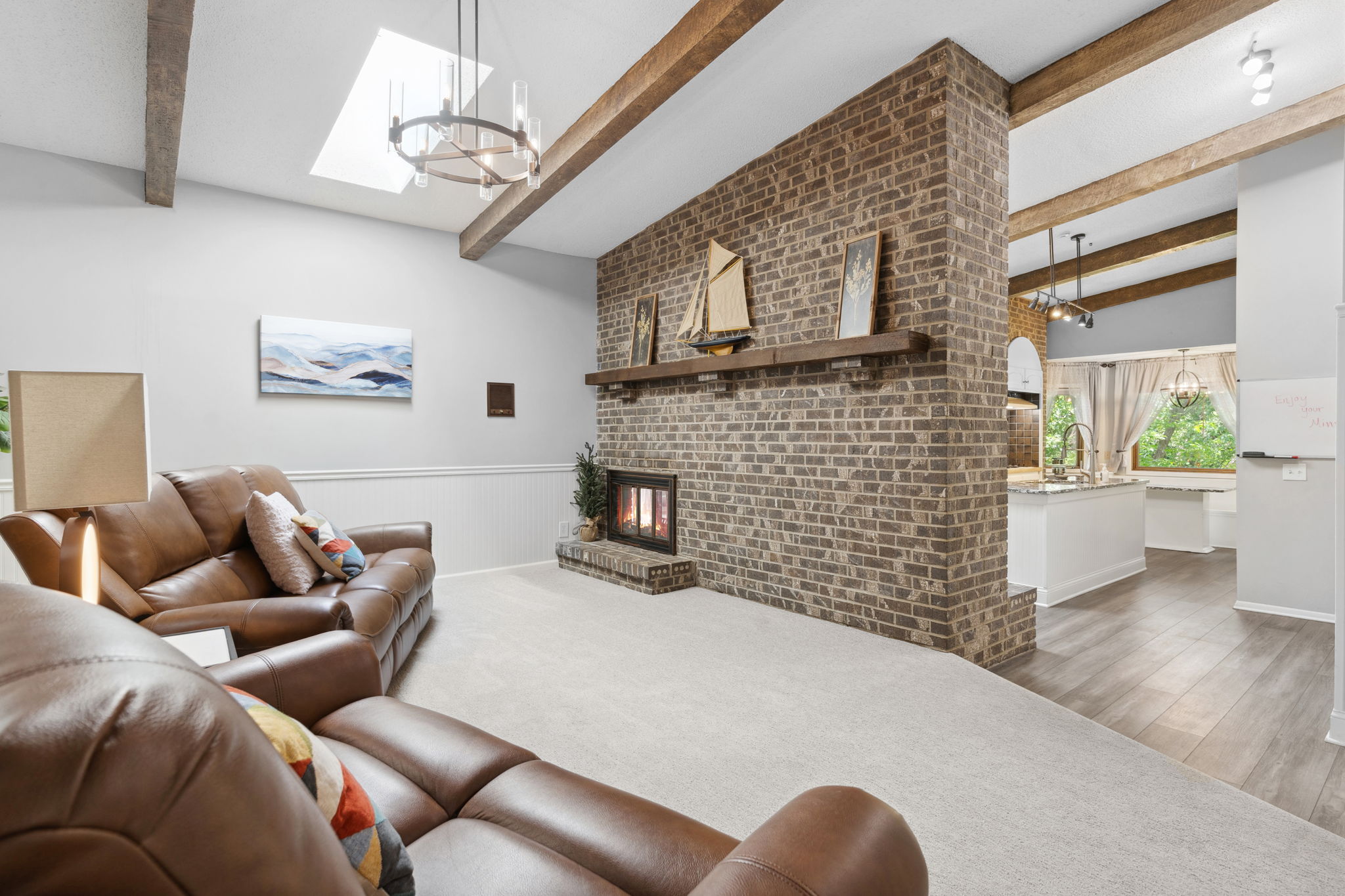 A cozy living room with a warm brick fireplace and inviting decor.