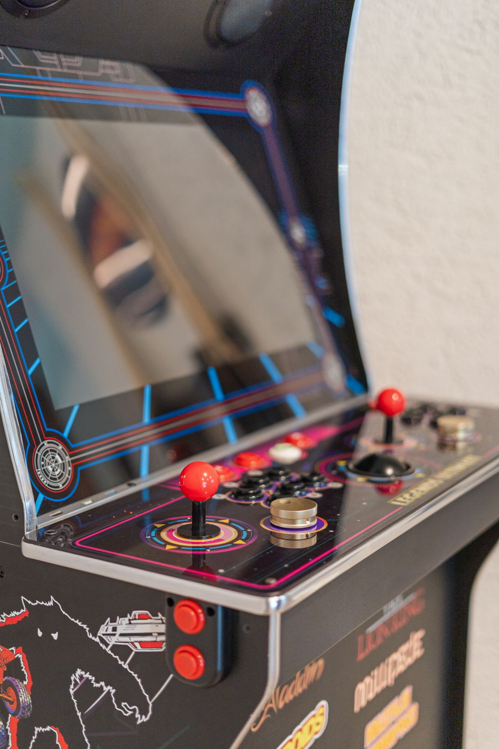A close-up of a colorful retro arcade game cabinet featuring bright controls and unique artwork.