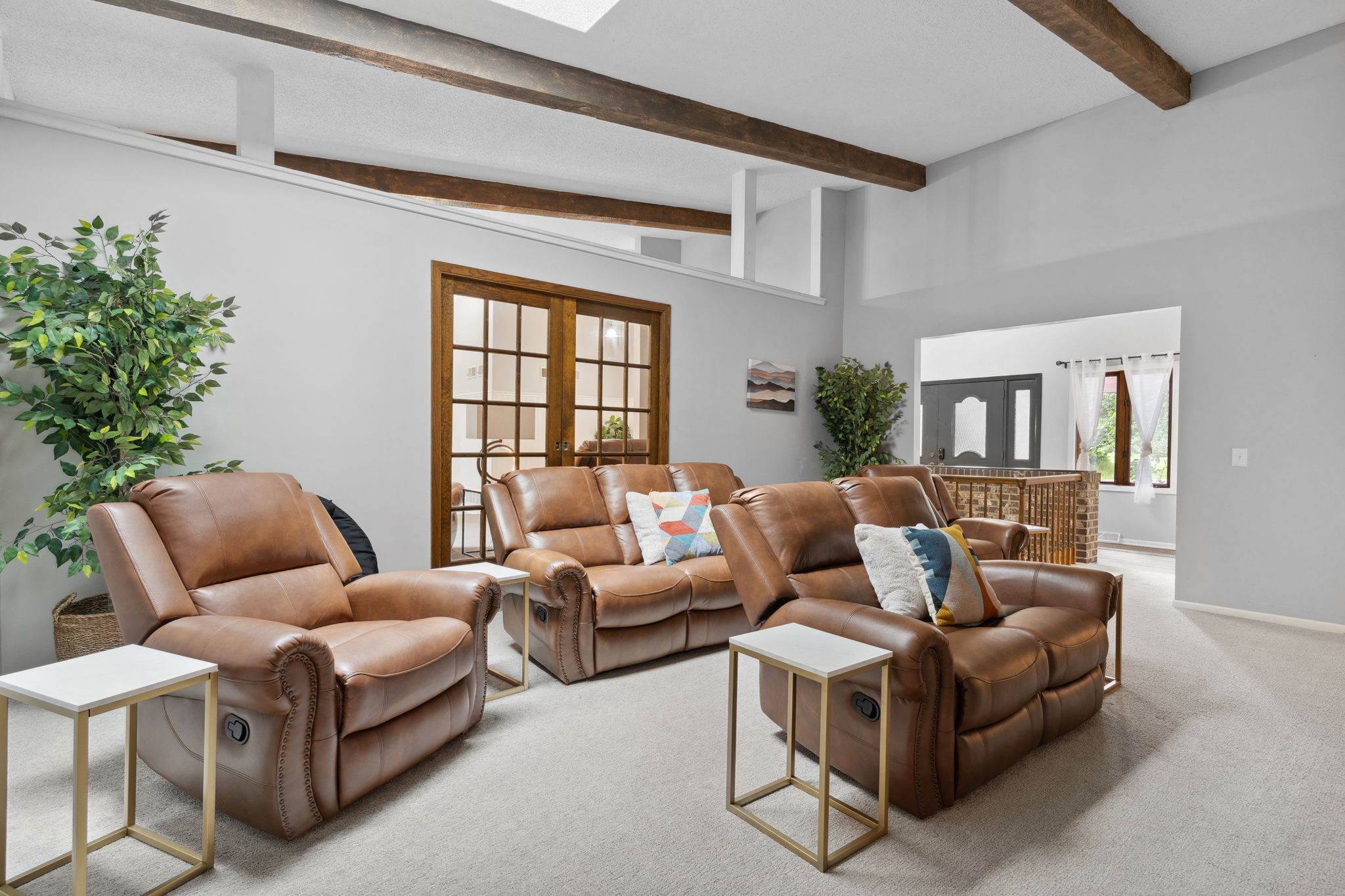 Cozy living room with brown recliners and natural light from a skylight.