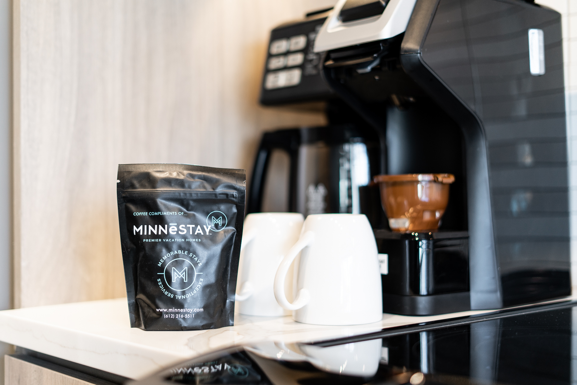 A modern coffee setup featuring MINNESTAY coffee bag and white mugs.