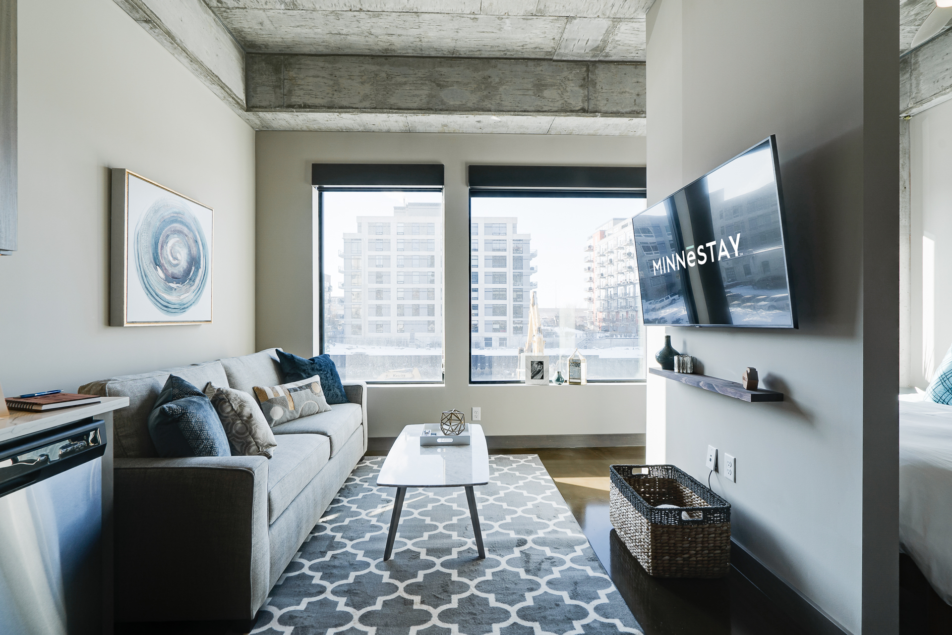 Stylish living room with a gray sofa, coffee table, and large windows.