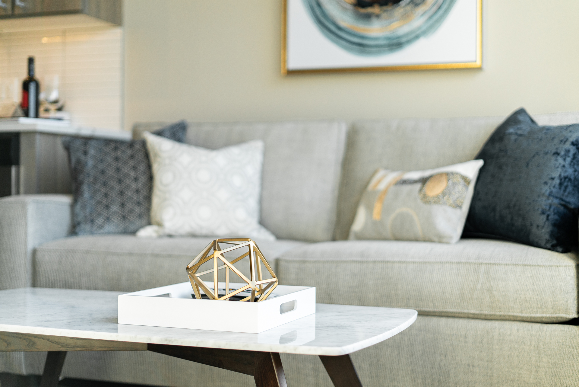 Modern living room decor featuring a gray couch, geometric sculpture, and stylish accessories.