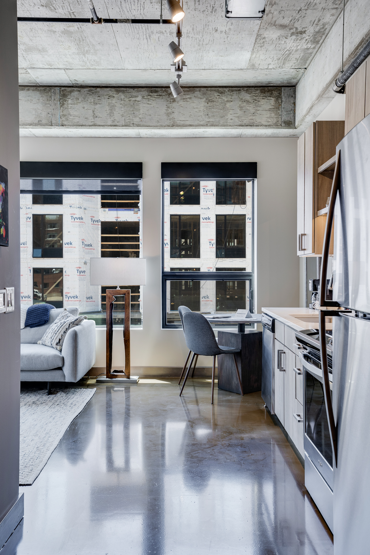 A chic industrial apartment interior featuring a living area and kitchen with modern amenities.
