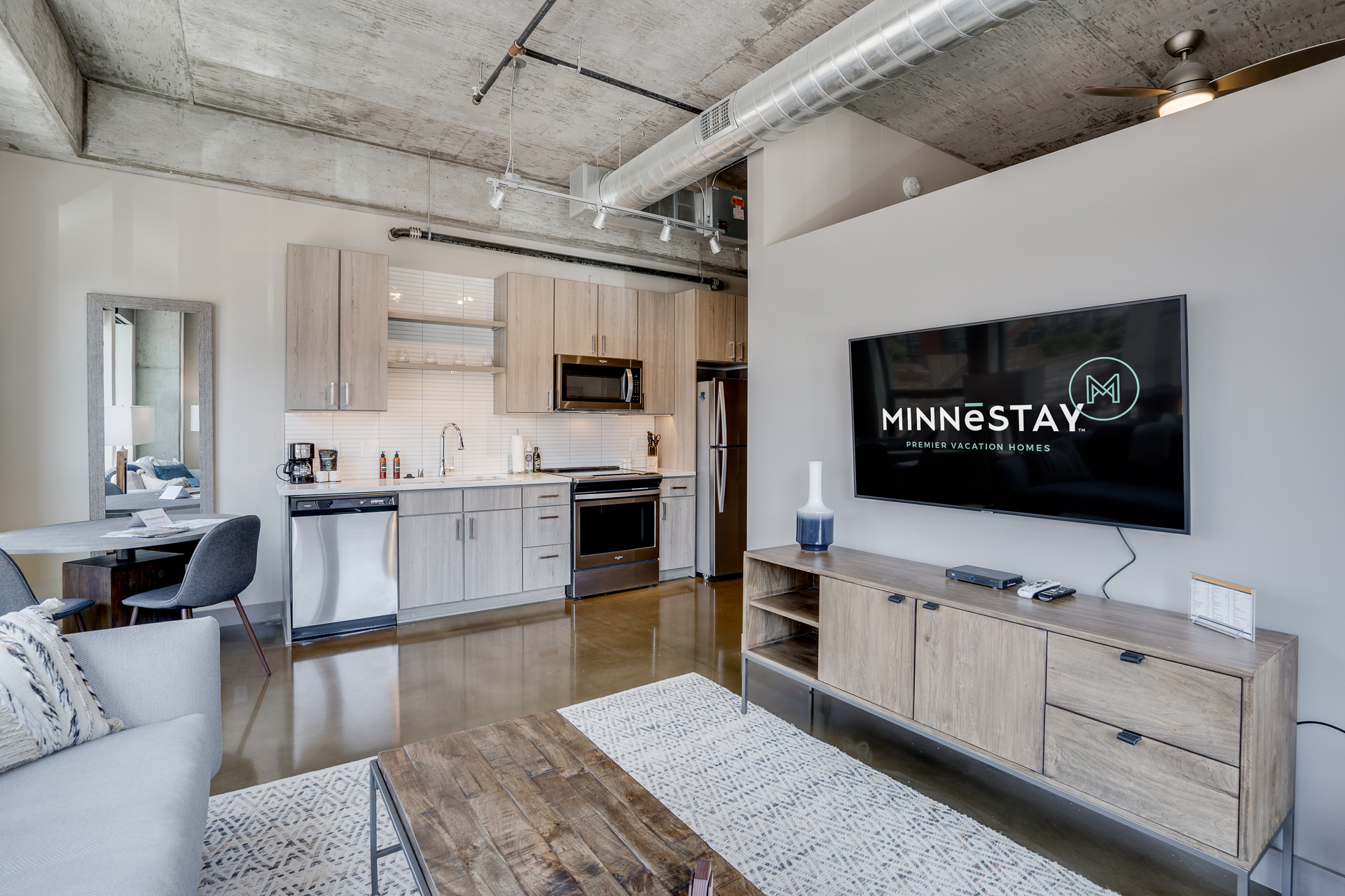 A stylish urban living room featuring a modern kitchen and cozy seating area.