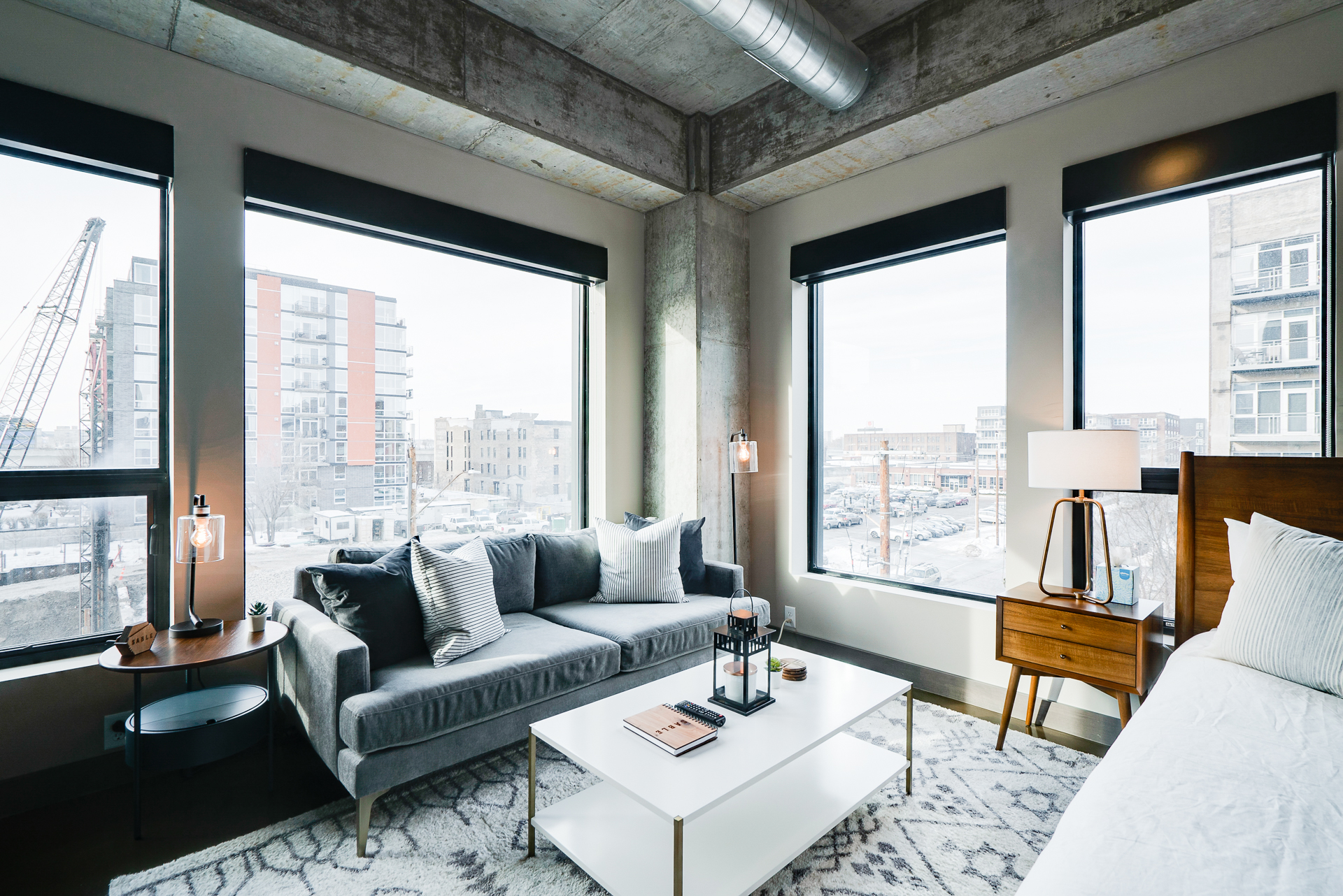 A stylish apartment with modern decor and expansive windows showcasing urban views.