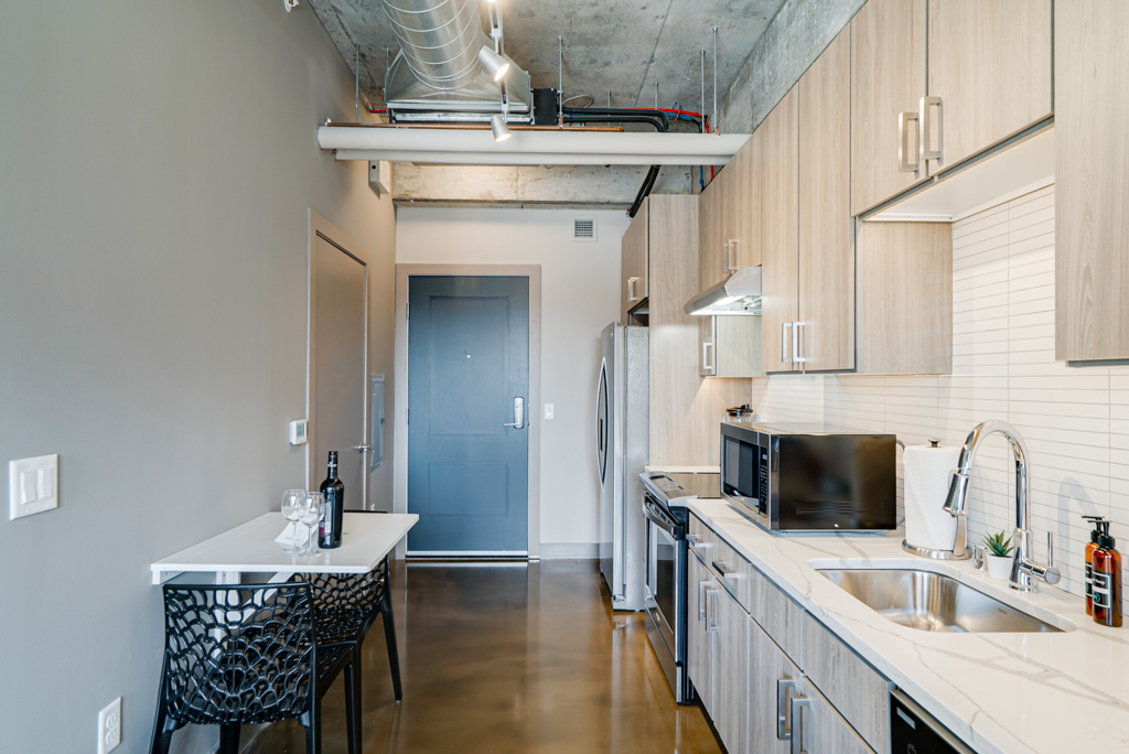 A modern kitchen area with light wood cabinetry and contemporary design.