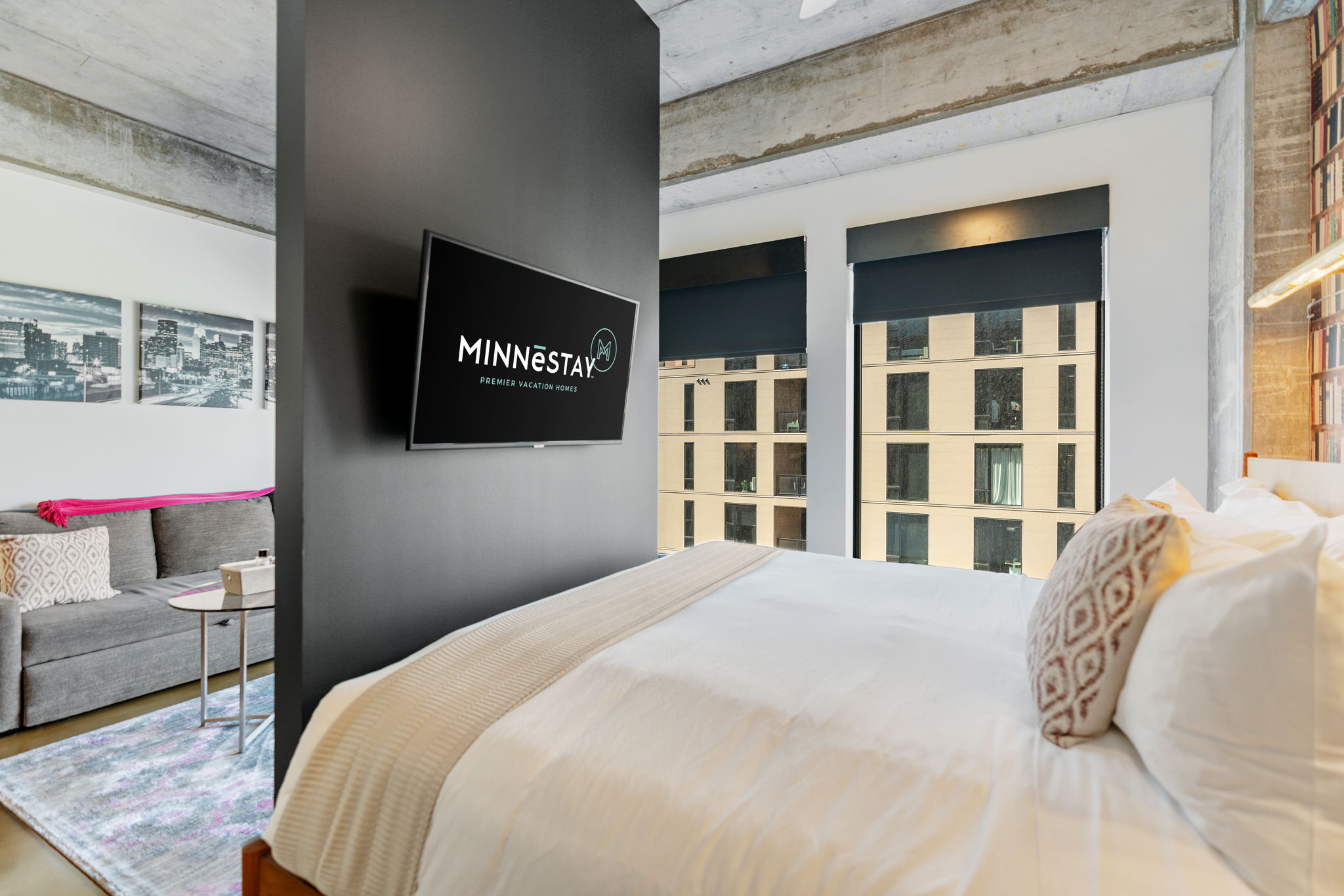 A modern studio apartment featuring a cozy bed and stylish decor.