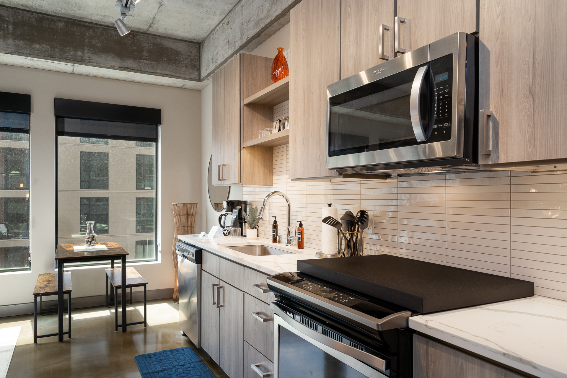 Modern kitchen with light wood cabinetry and stainless steel appliances.