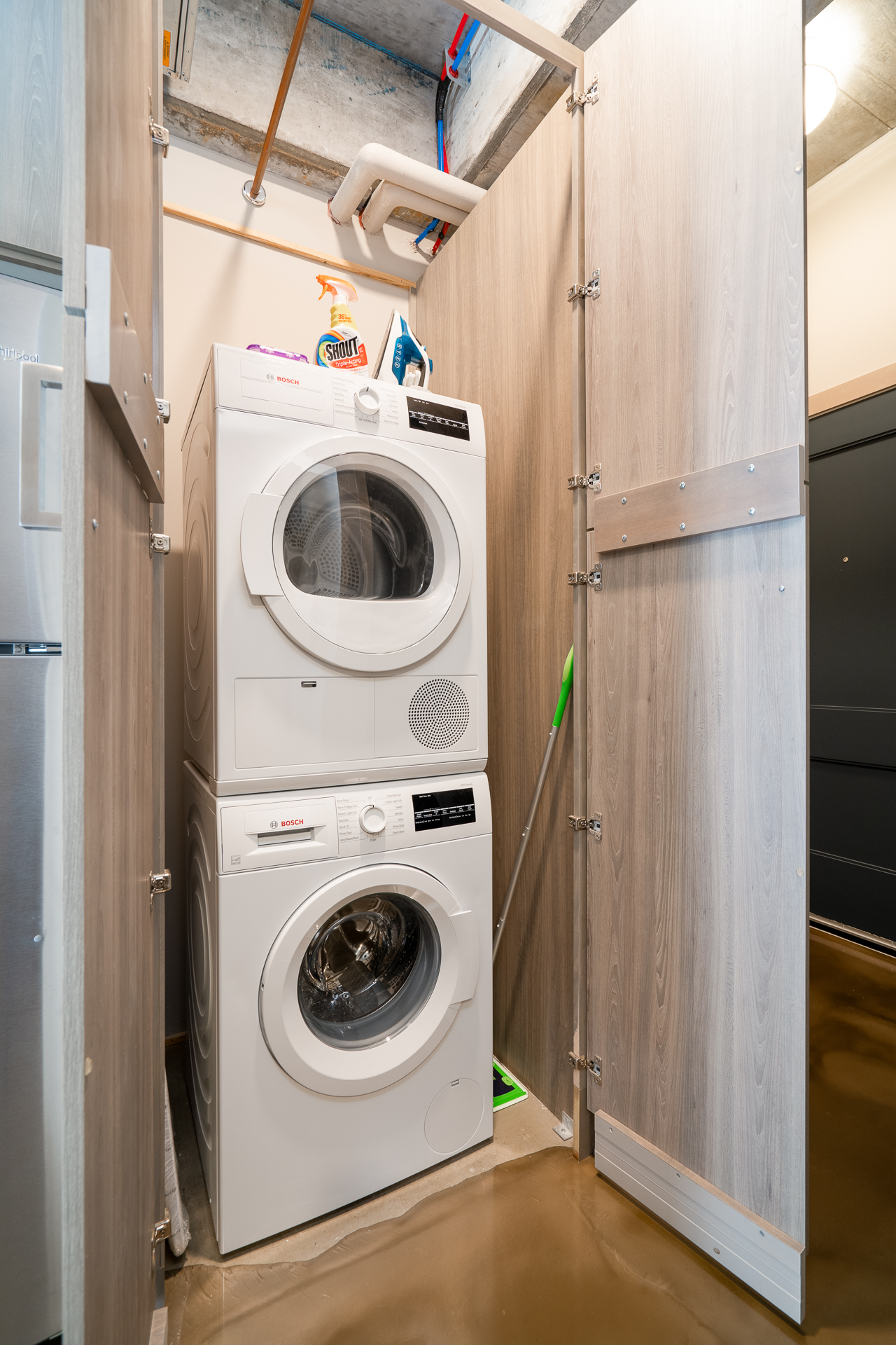 Compact laundry area with stacked Bosch washer and dryer.