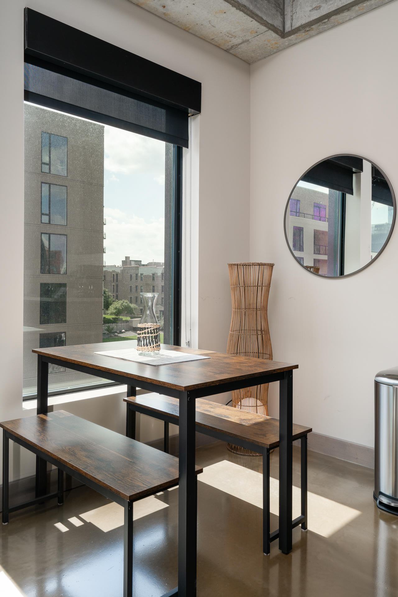 A modern dining area with a stylish wooden table, benches, and natural light.