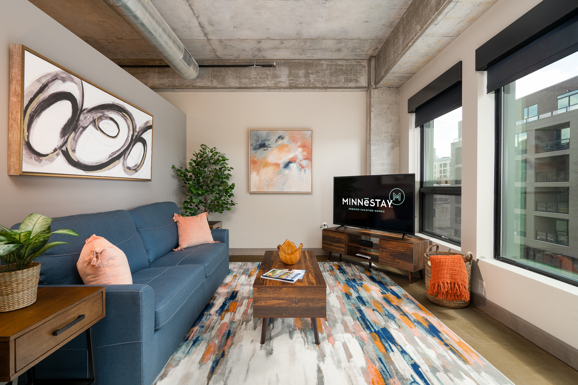 Cozy living room with blue sofa, abstract artwork, and television.