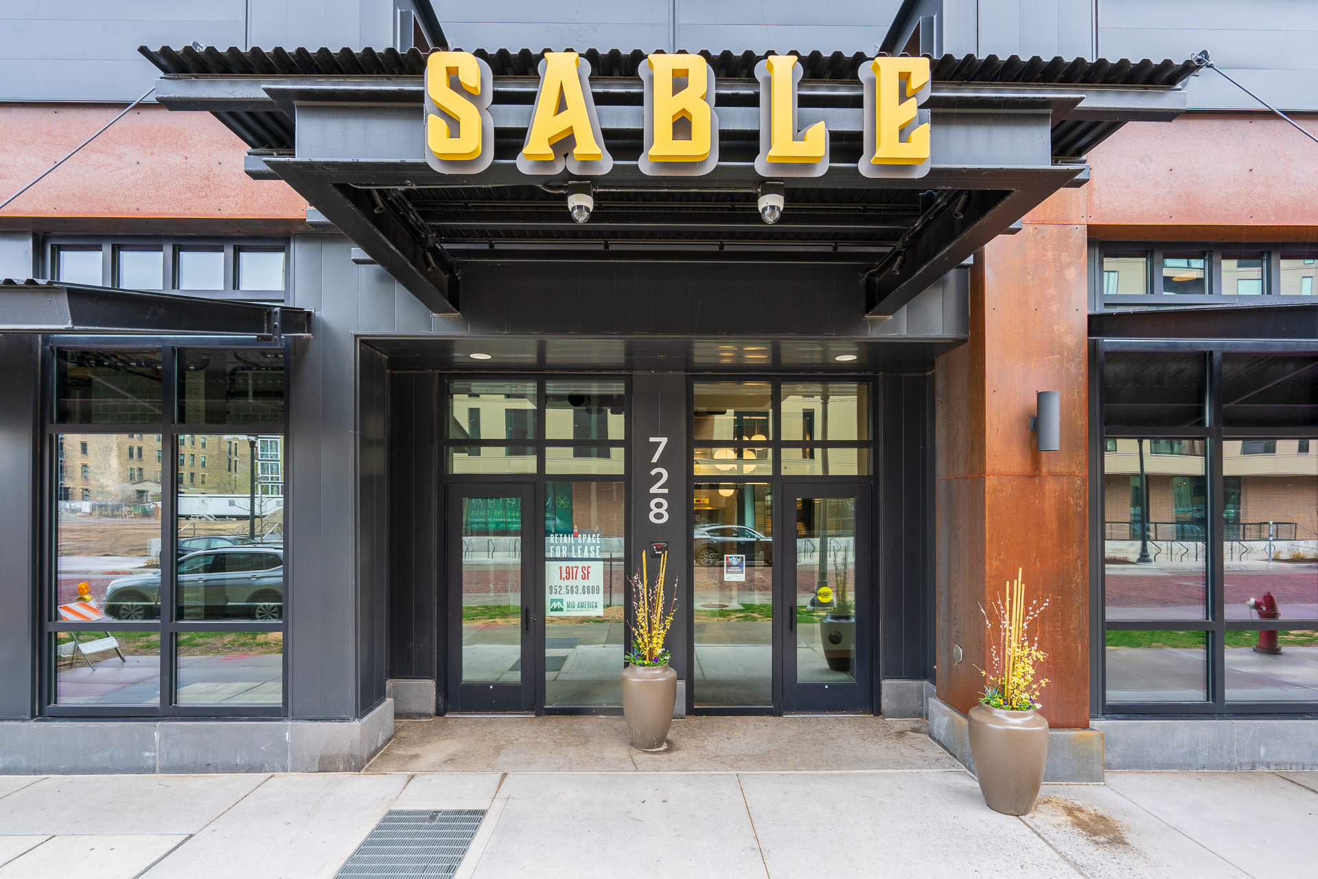 The modern entrance to SABLE at 728, showcasing bold signage and inviting decor.