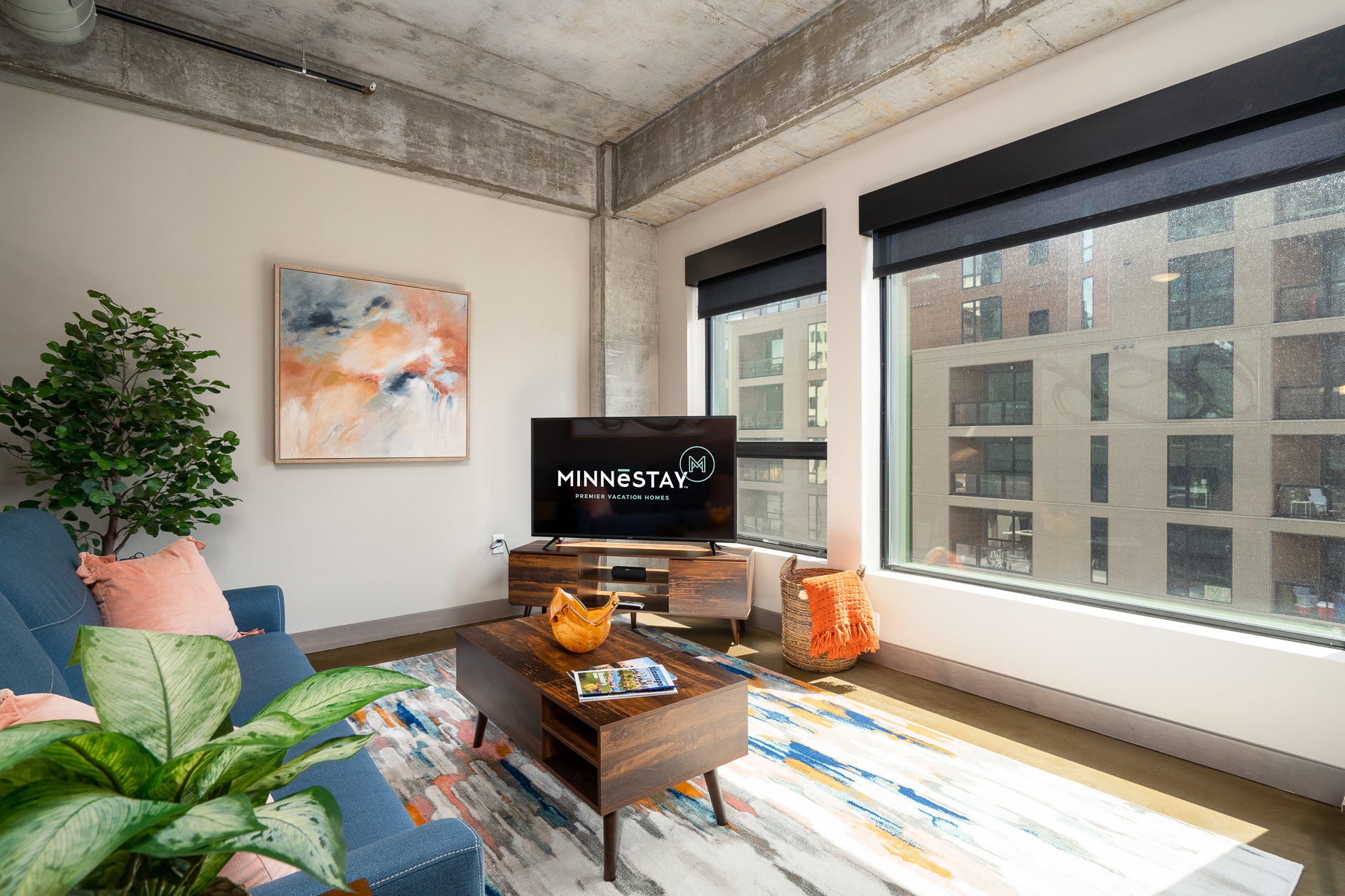 Modern living room featuring a cozy blue sofa, vibrant rug, and stylish decor.