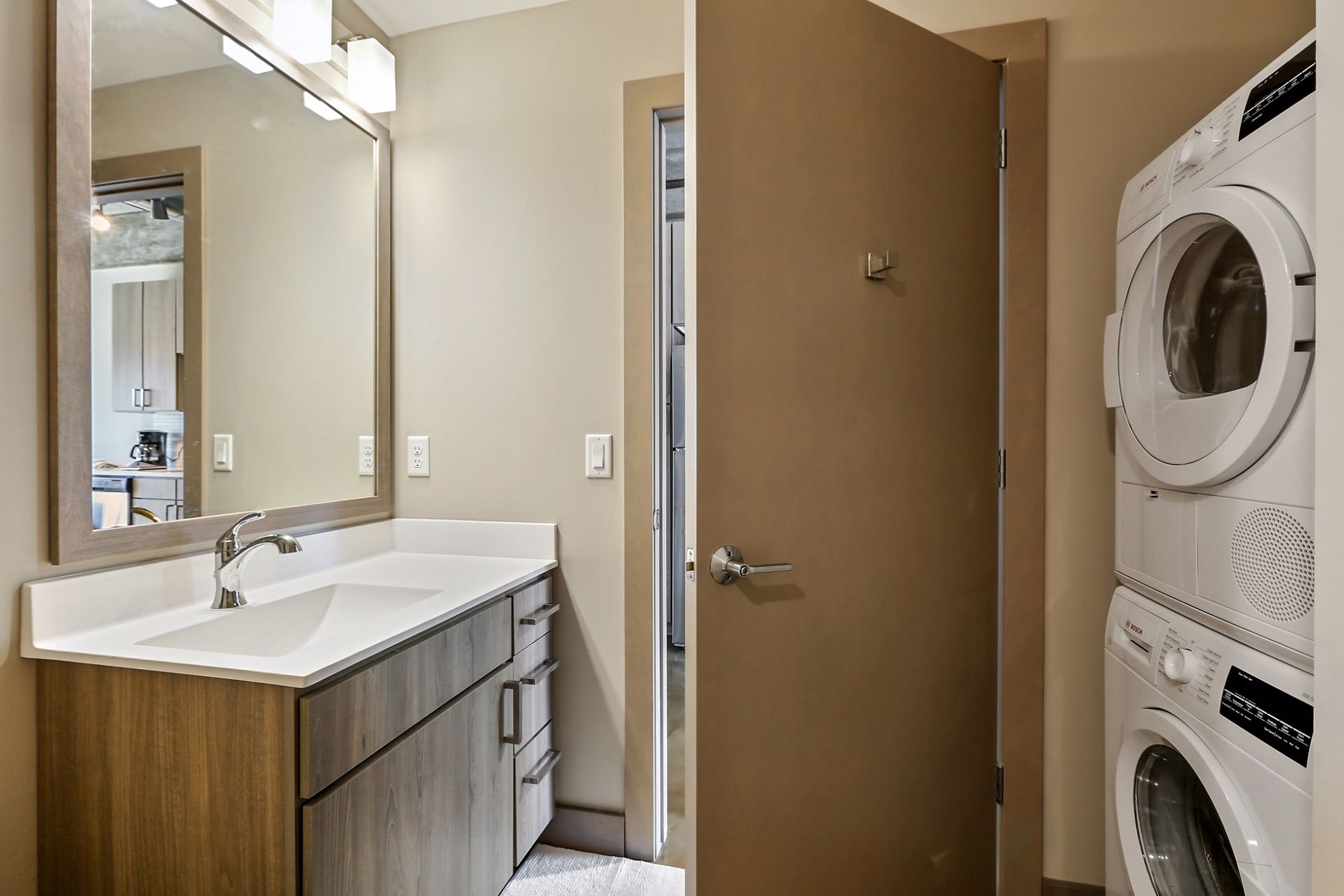A modern bathroom with a stylish vanity and an adjacent laundry area.