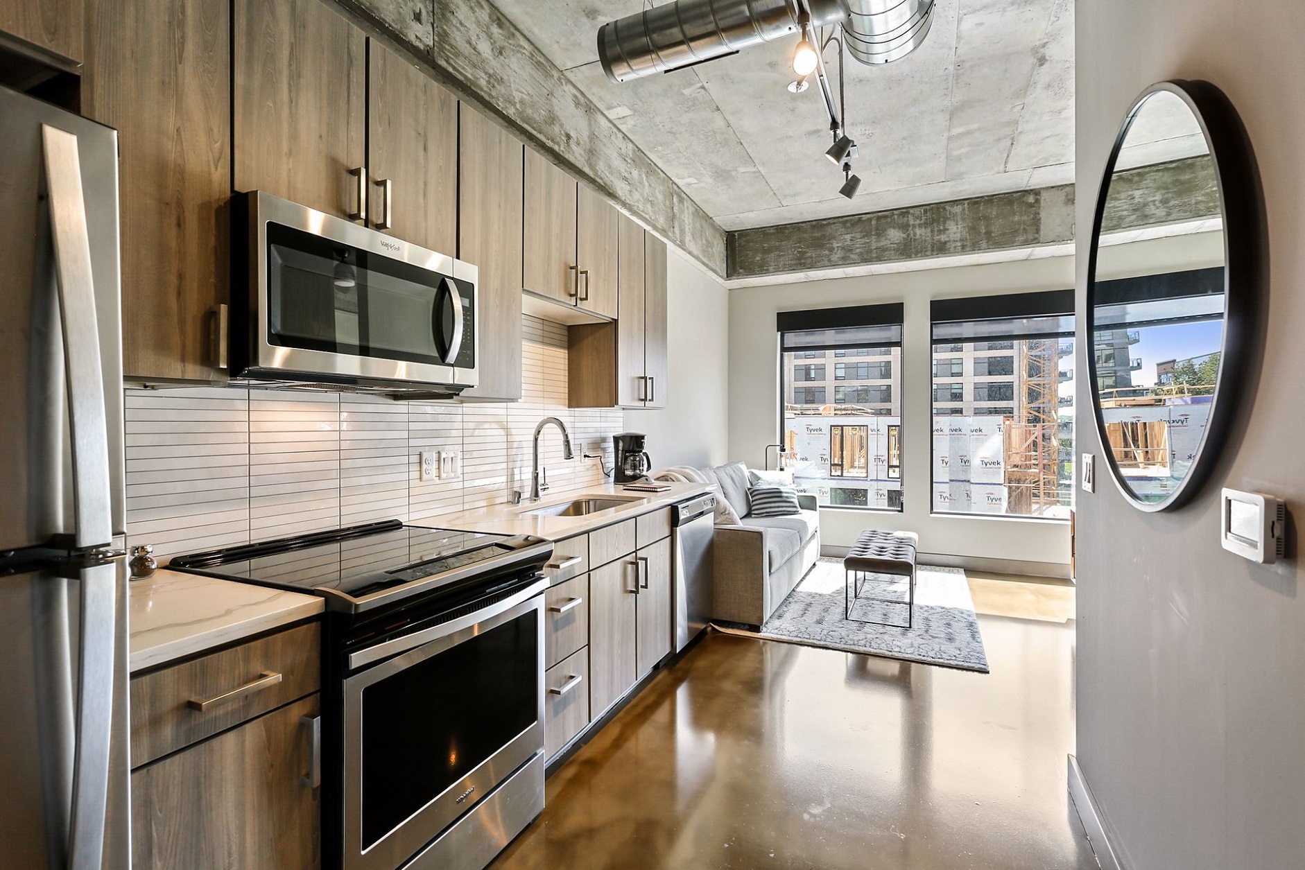 A modern kitchen and living area featuring sleek design and ample natural light.