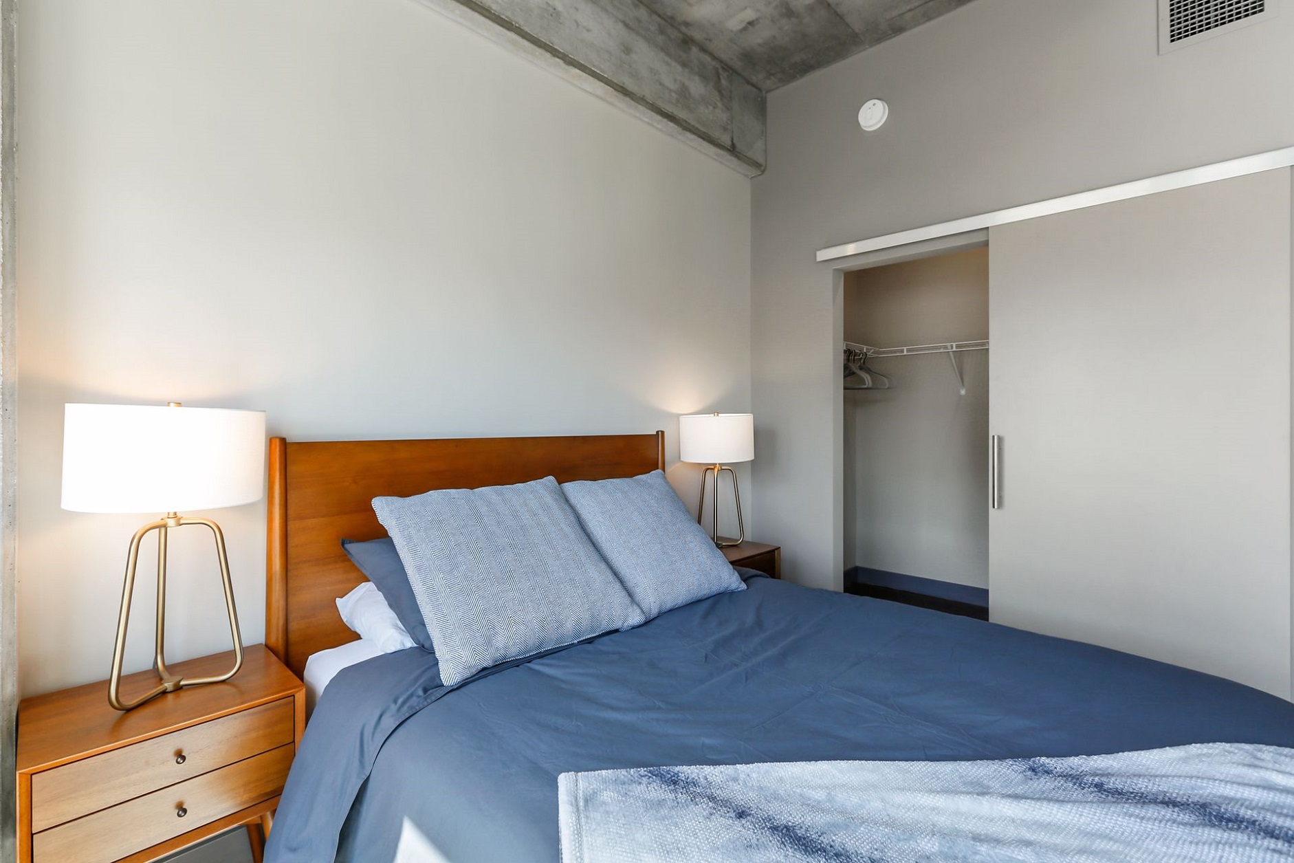 A cozy modern bedroom featuring a navy blue bedspread and stylish furnishings.