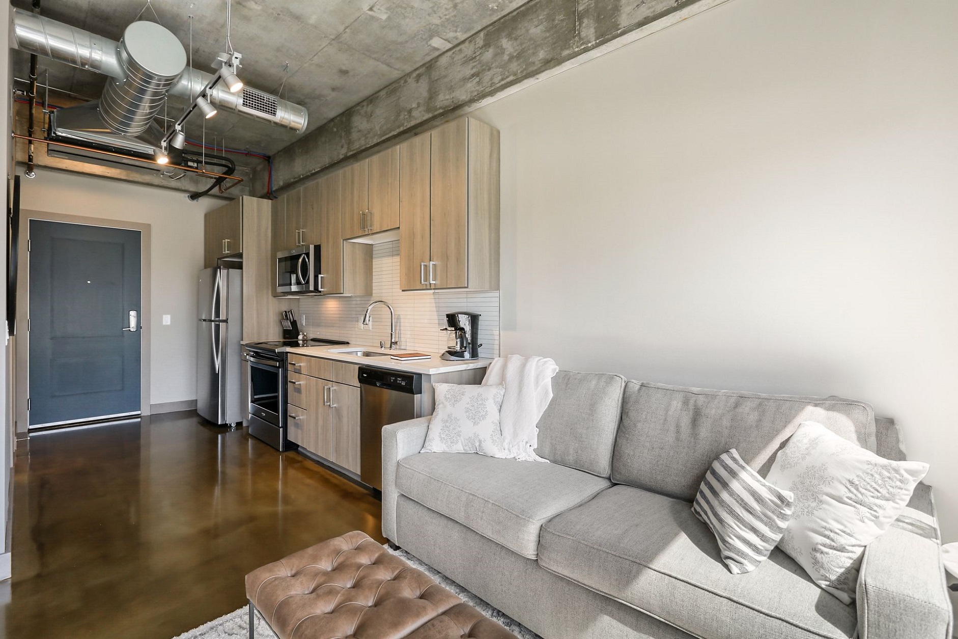 A modern apartment interior featuring a sleek kitchen and cozy living area.