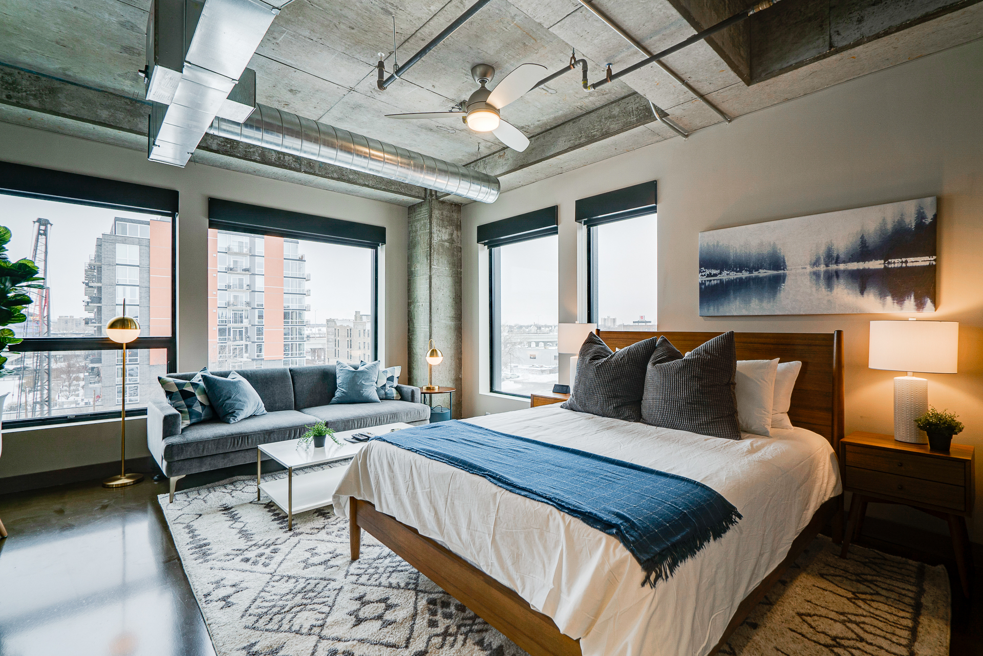 A modern urban bedroom featuring stylish decor and city skyline views.