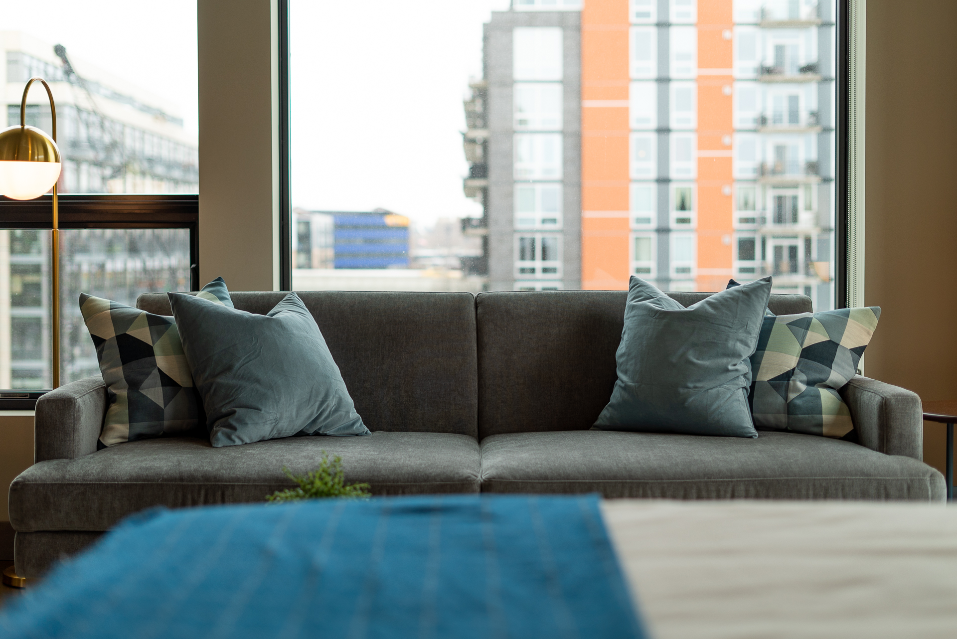 A modern gray sofa with decorative pillows in a bright urban living room.