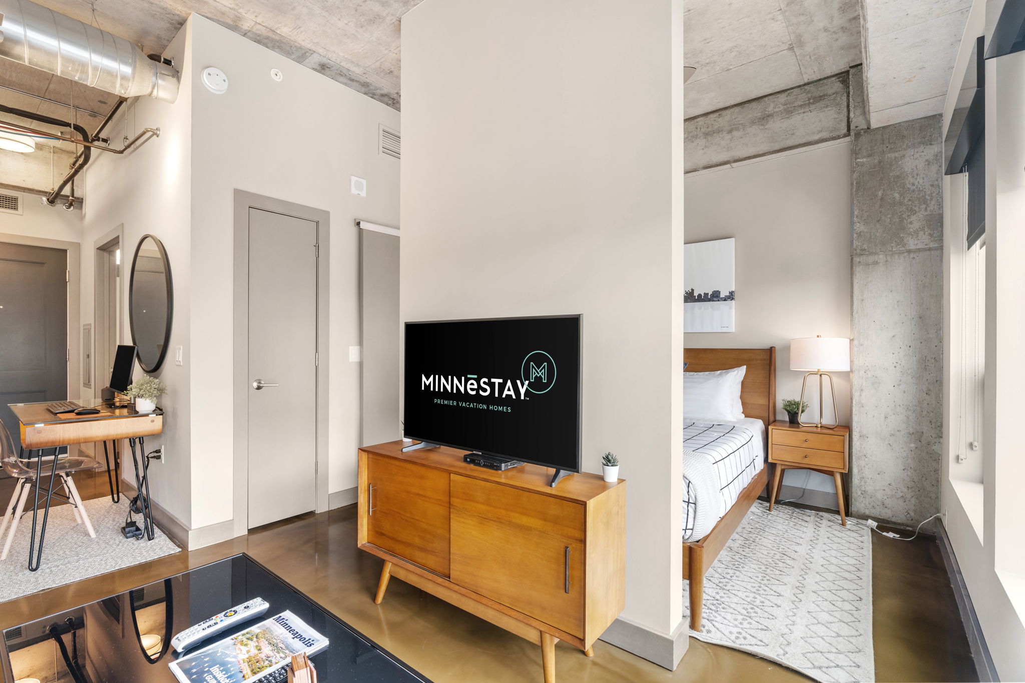 A modern living space featuring a stylish bedroom and a cozy work area.