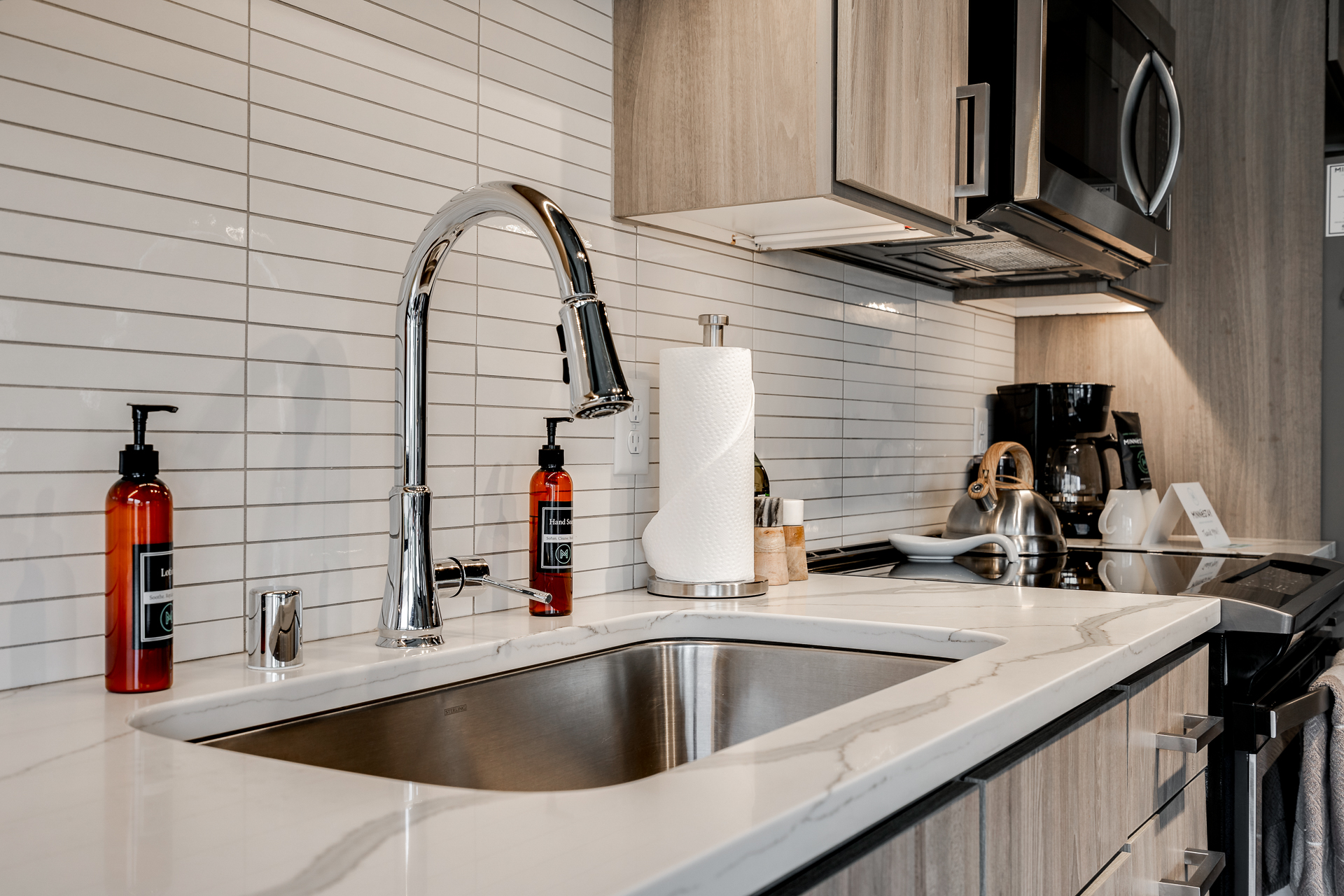 A modern kitchen countertop with a stainless steel sink and sleek fixtures.