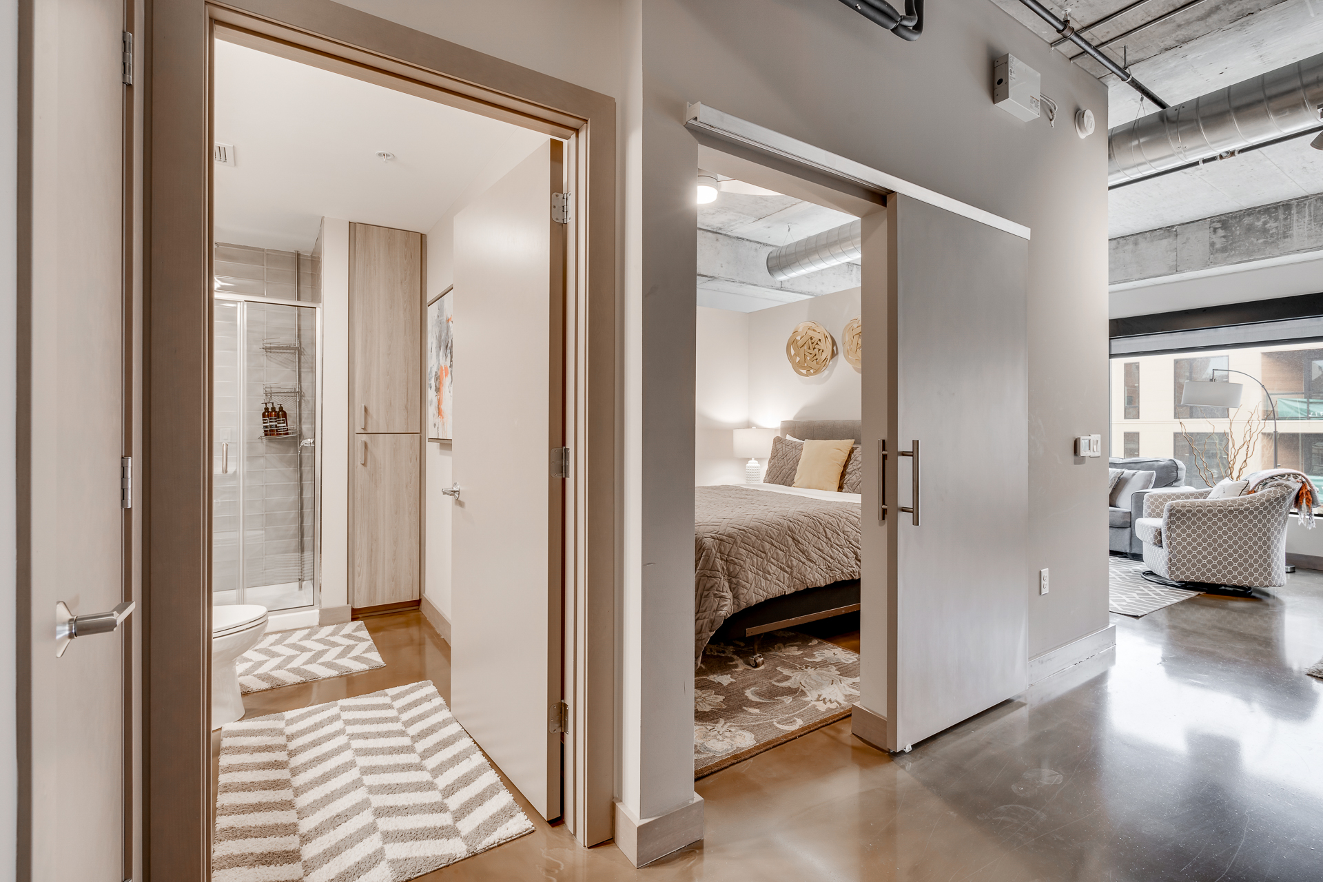 A modern apartment interior featuring a cozy bedroom and stylish bathroom.