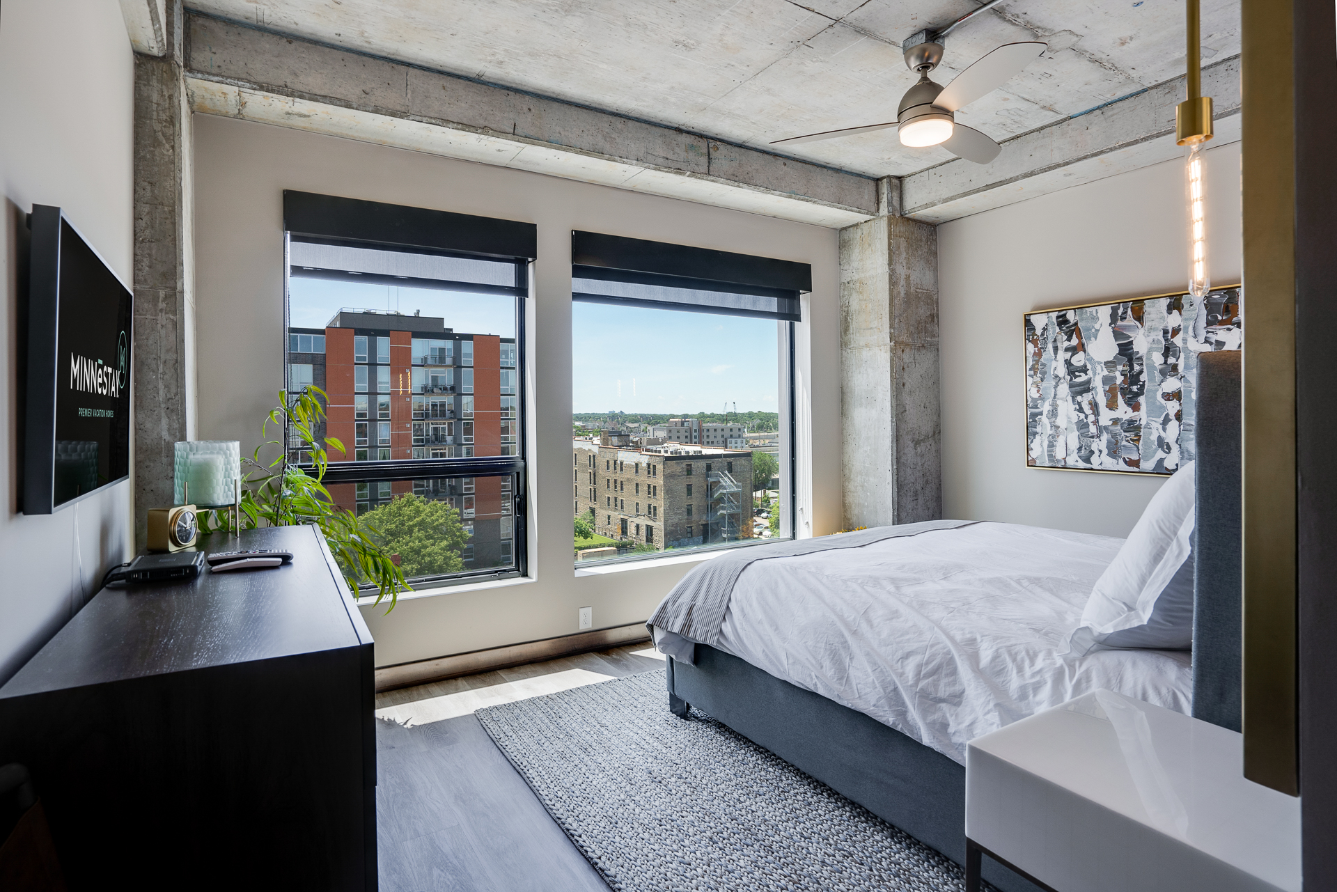 A modern bedroom with urban views and stylish decor.