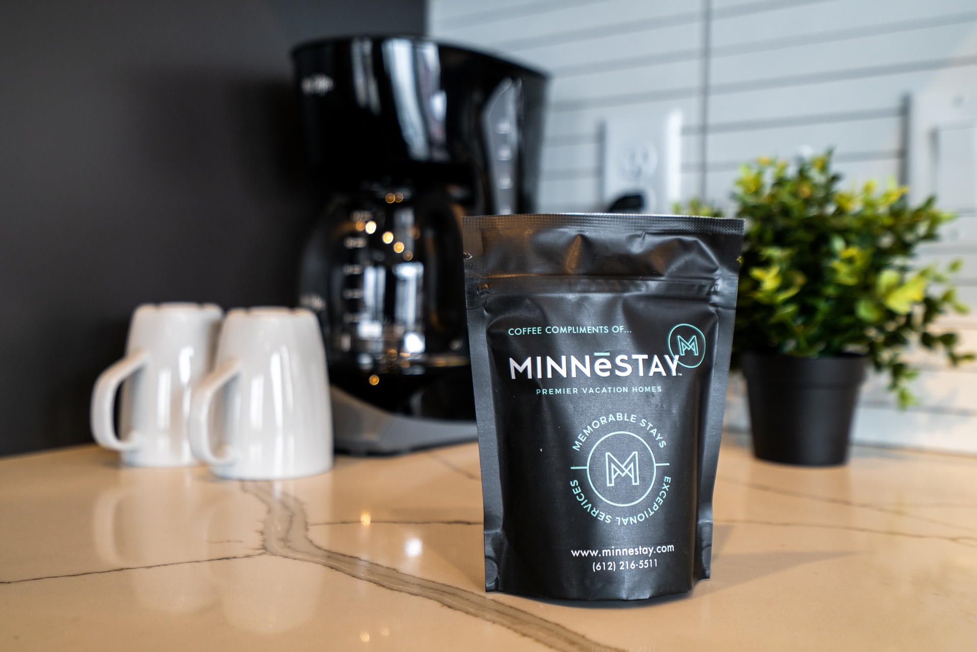 A coffee bag and mugs in a stylish kitchen environment.