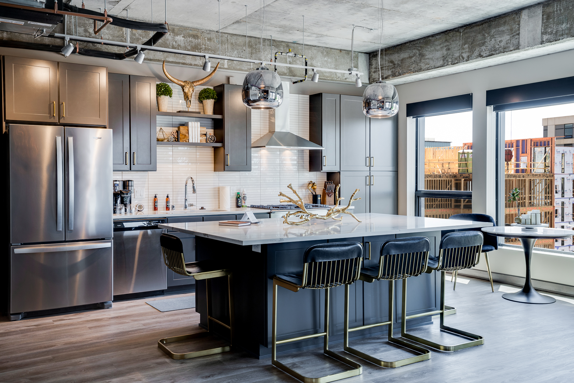 Stylish modern kitchen with a central island, stainless steel appliances, and large windows.