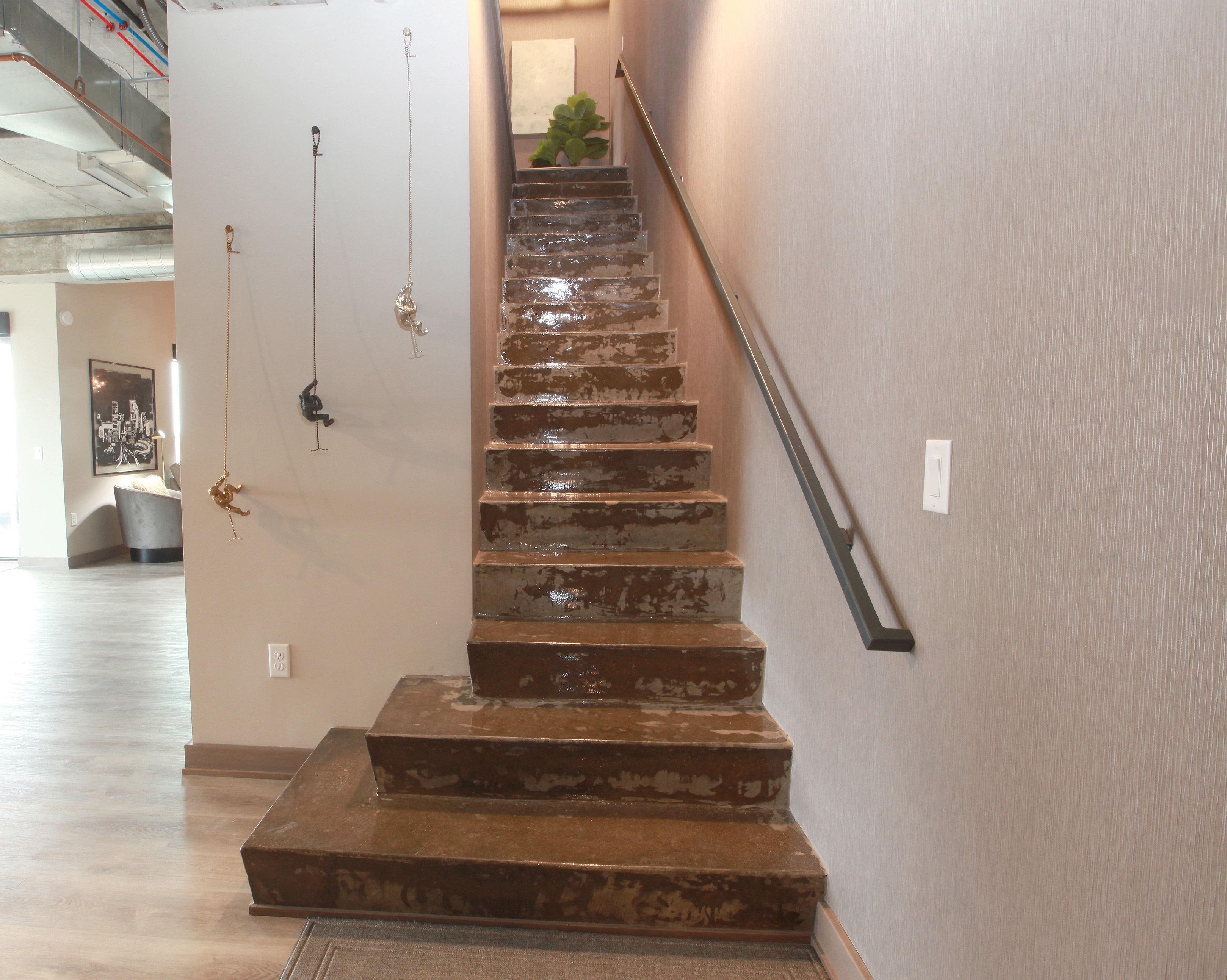 A stylish staircase with playful monkey decor and polished concrete steps.