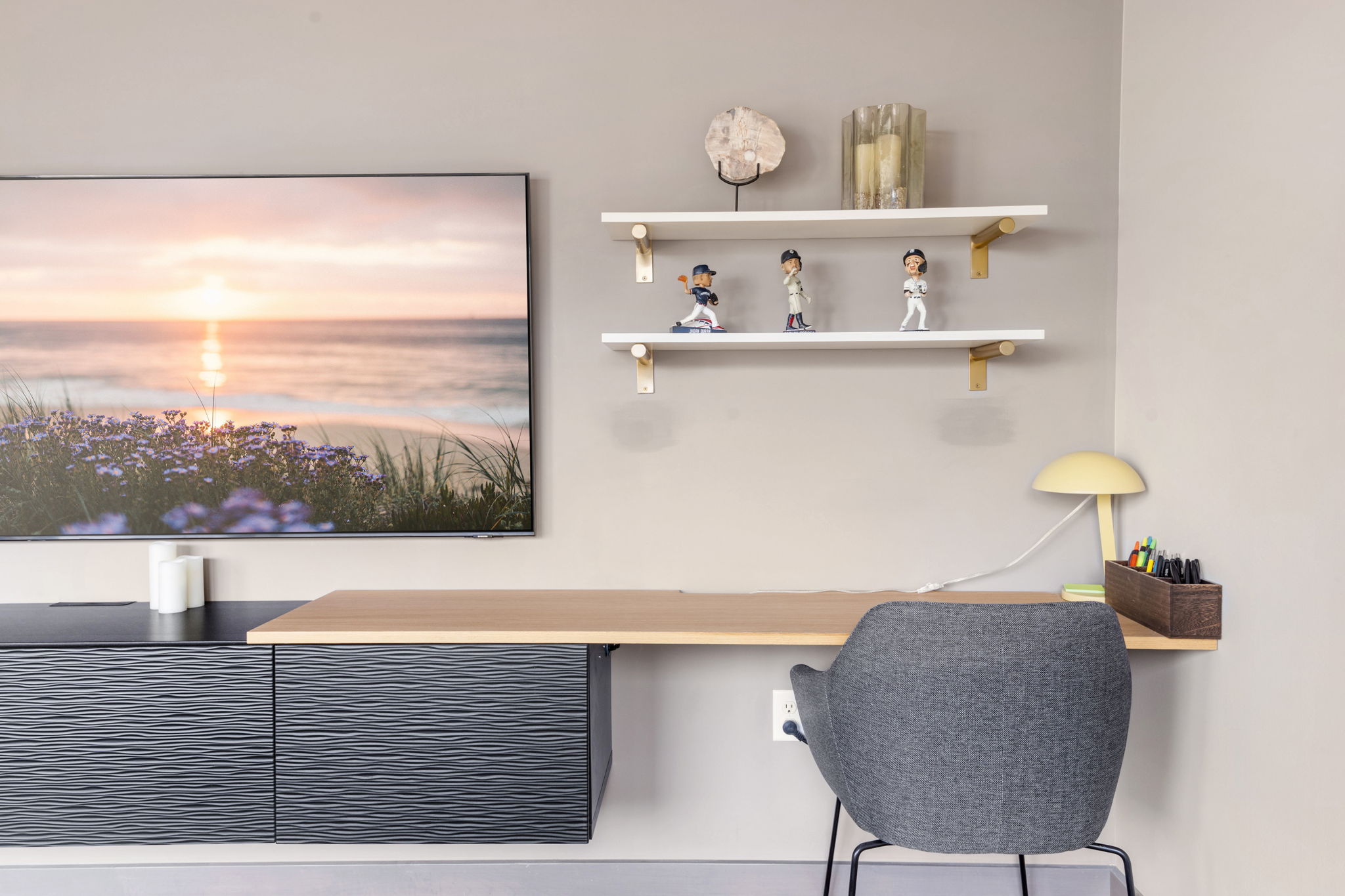 A modern workspace with a serene beach landscape and decorative shelves.