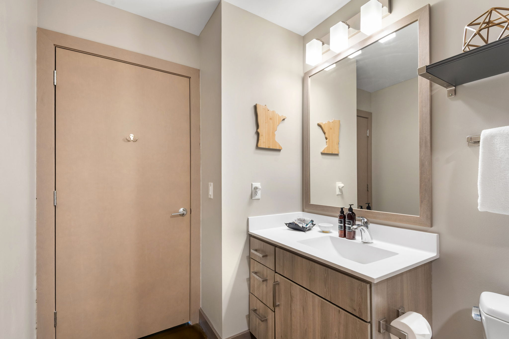 A stylish and modern bathroom with light wood accents.