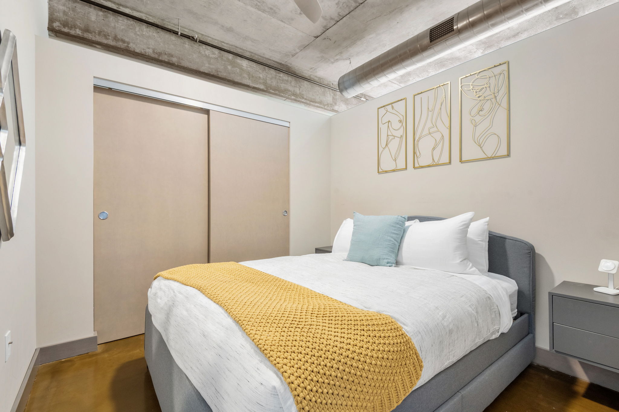 A modern bedroom featuring stylish decor and a cozy bed setup.