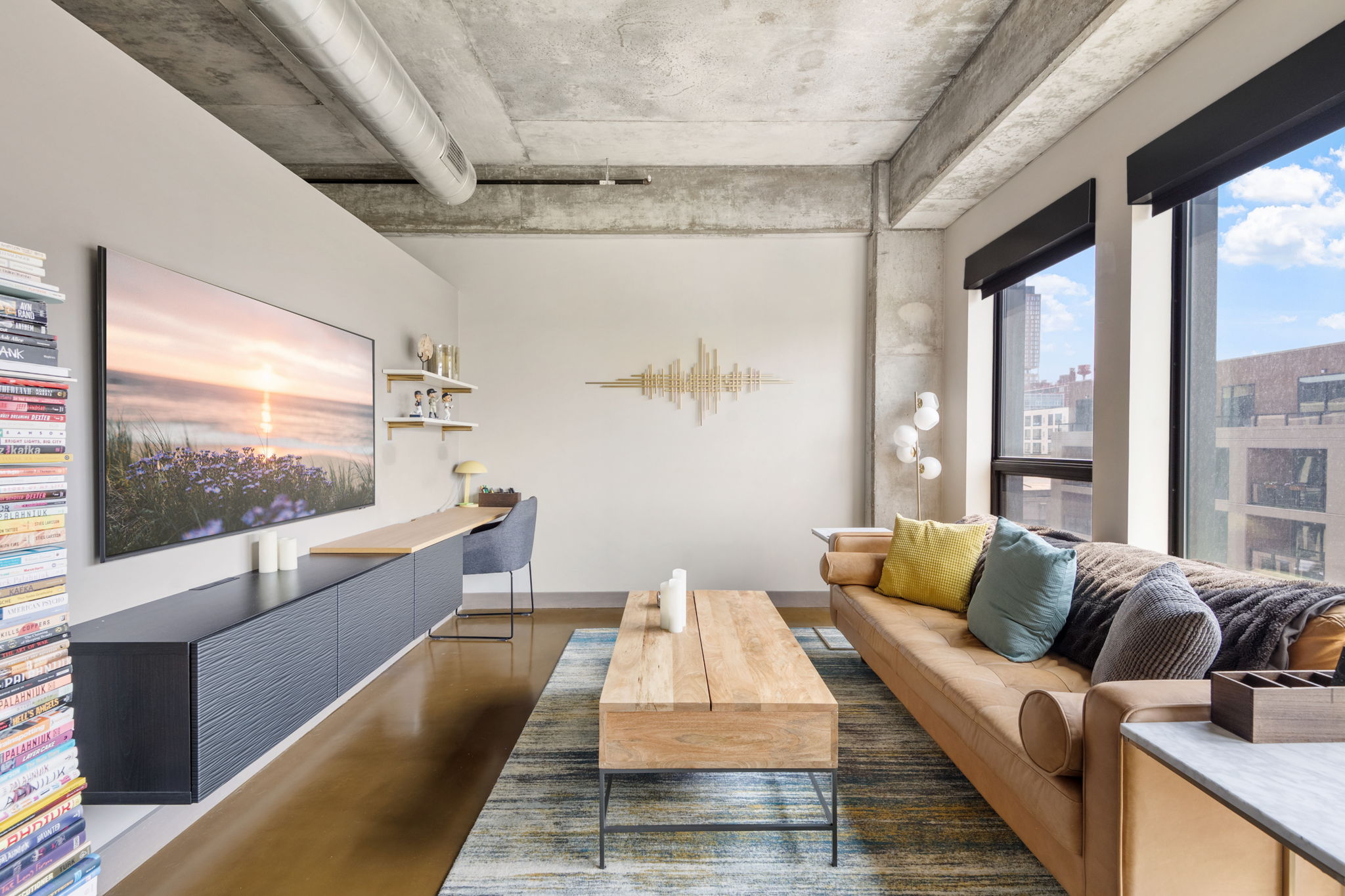 A bright and modern living room with industrial touches and cozy decor.