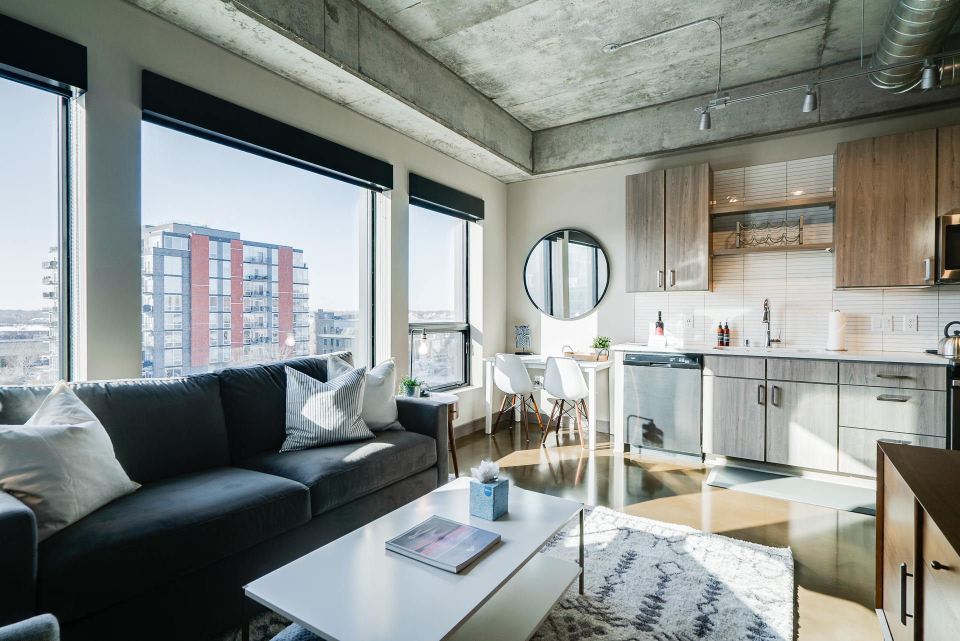A stylish and modern apartment interior featuring a cozy seating area and sleek kitchen.