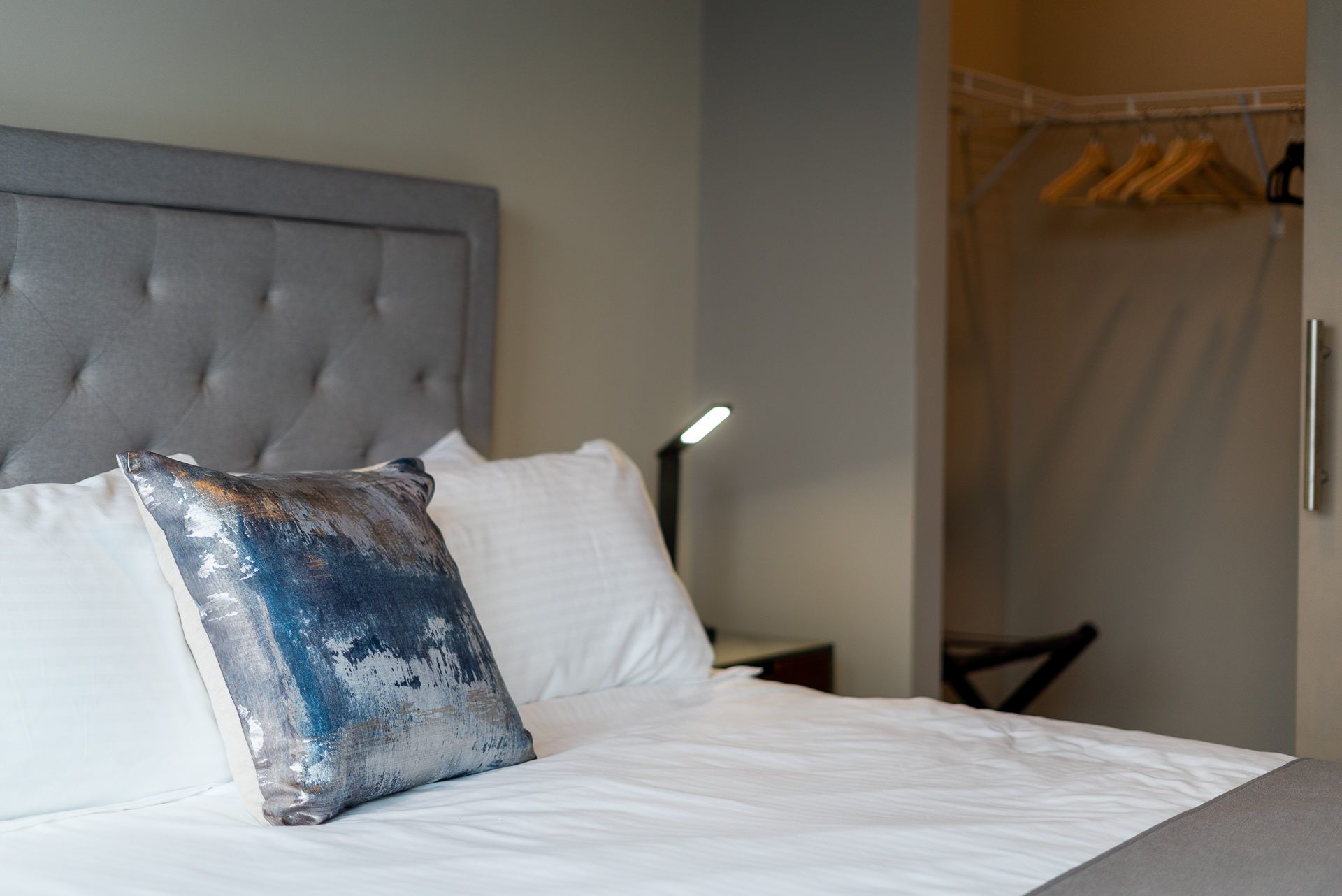 A modern hotel room featuring a stylish bed and decorative pillow.