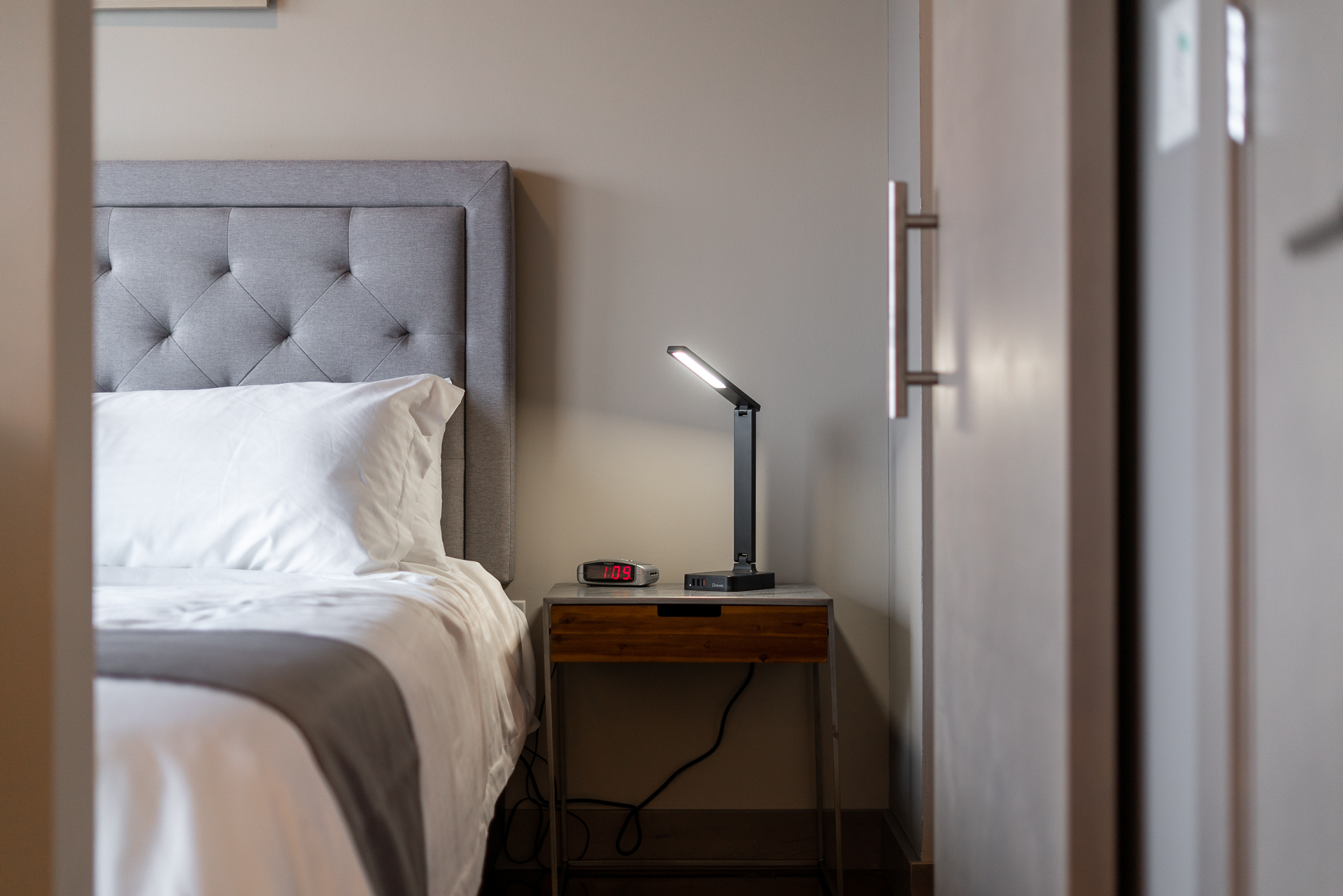 A cozy bedroom featuring a stylish tufted headboard and bedside essentials.