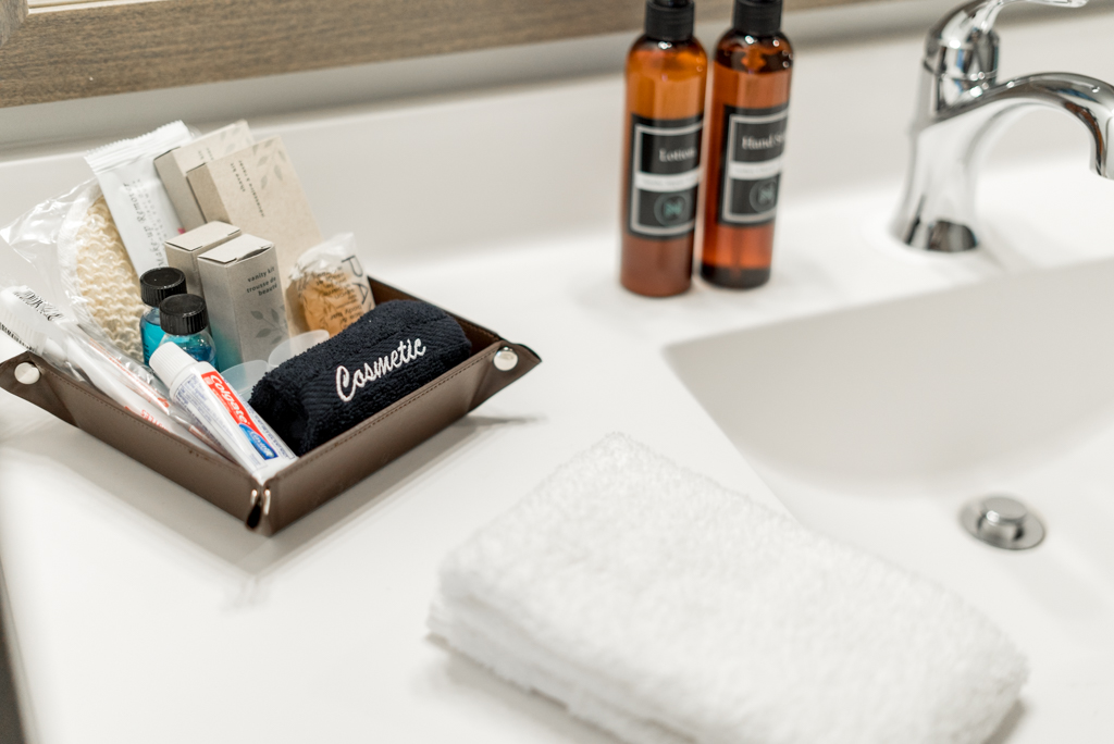 A well-organized bathroom counter featuring cosmetic items and a plush towel.