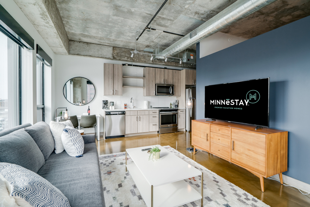 A stylish urban living room featuring modern decor and an open kitchen.