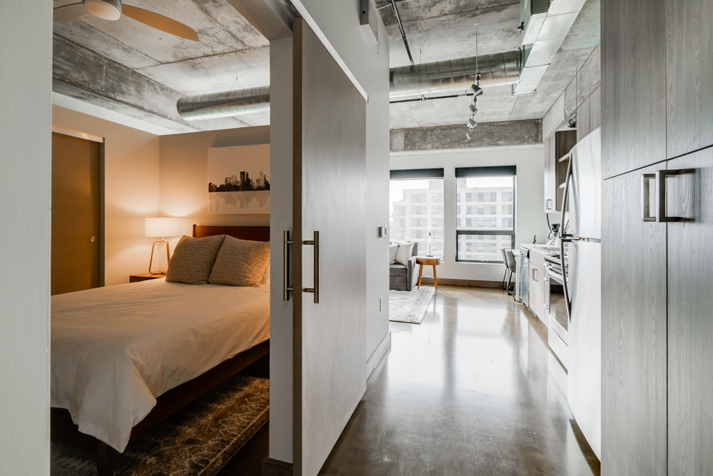 A modern apartment interior featuring a cozy bedroom and a stylish living area.