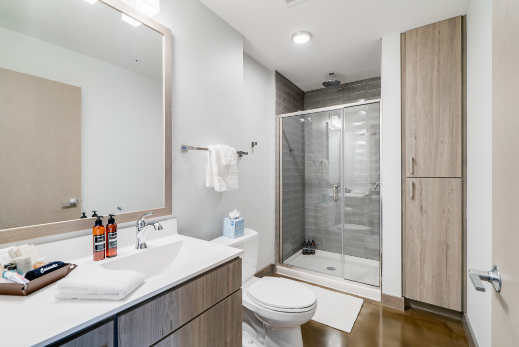 A modern, sleek bathroom featuring stylish amenities and a spacious shower.