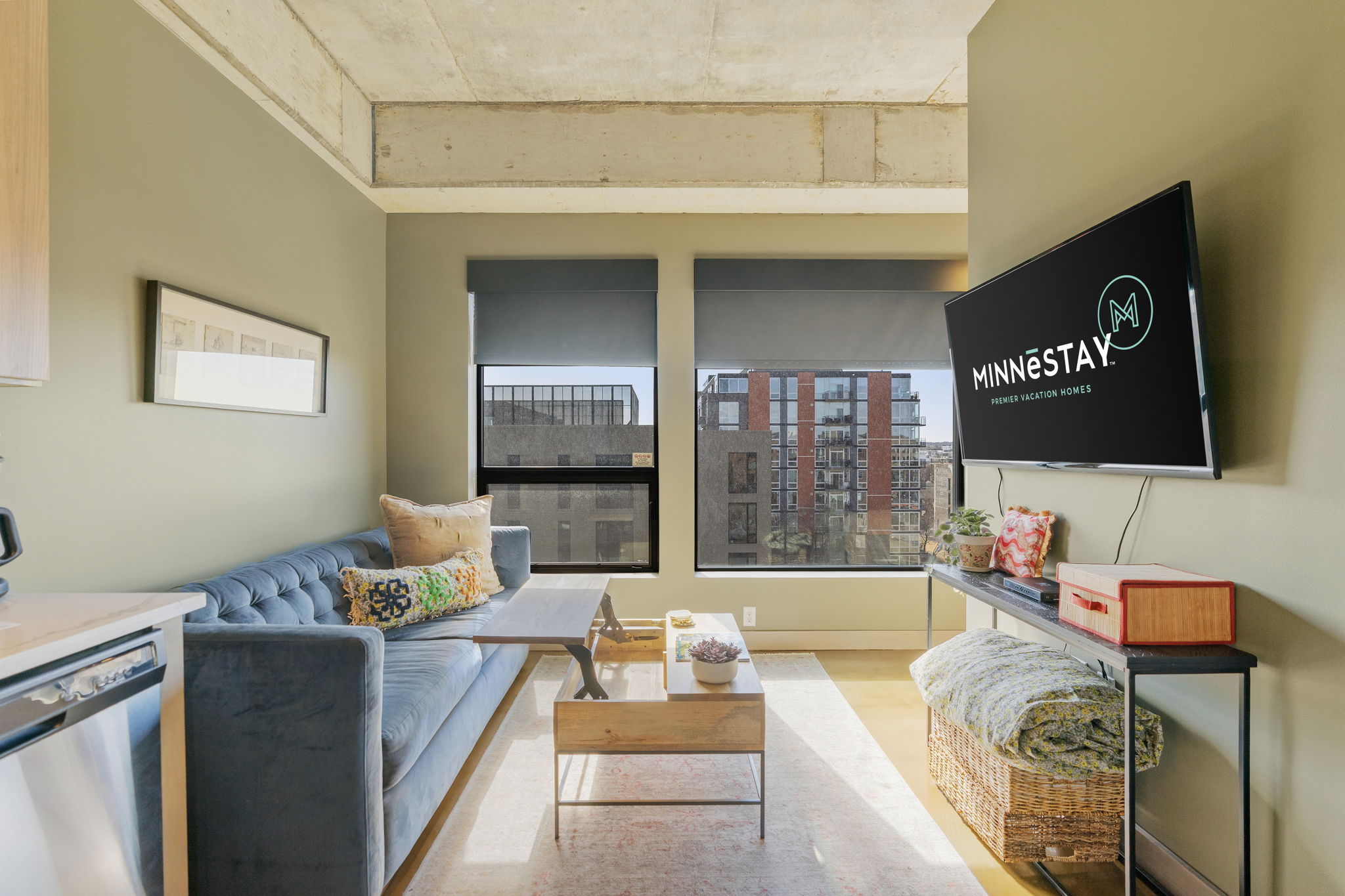 A cozy modern living room featuring a plush blue sofa and a stylish TV display.