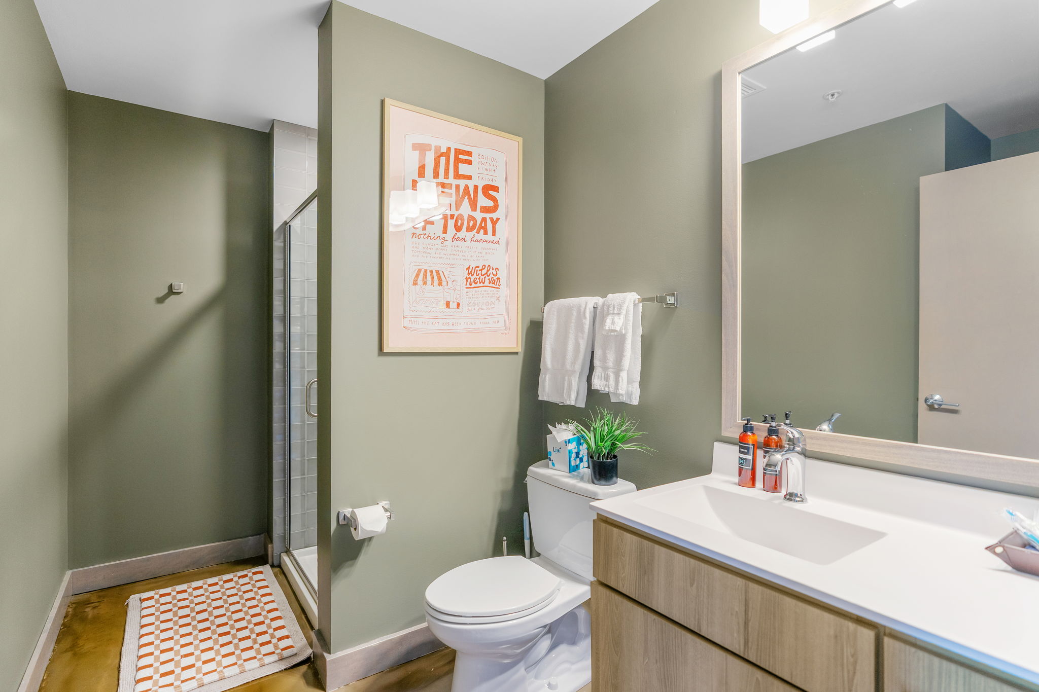 A modern bathroom with earthy green walls and stylish decor.