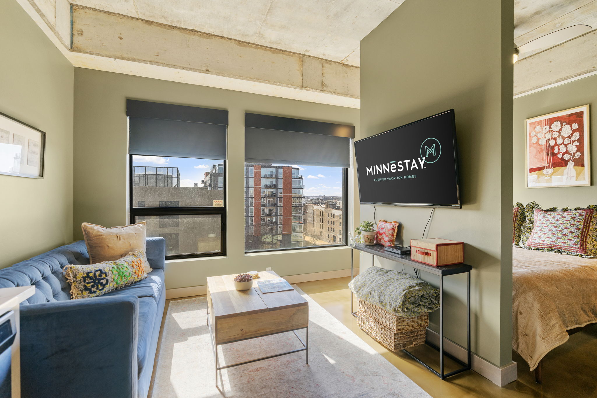 A stylish and modern living space featuring a blue couch and a flat-screen TV in an urban vacation rental.