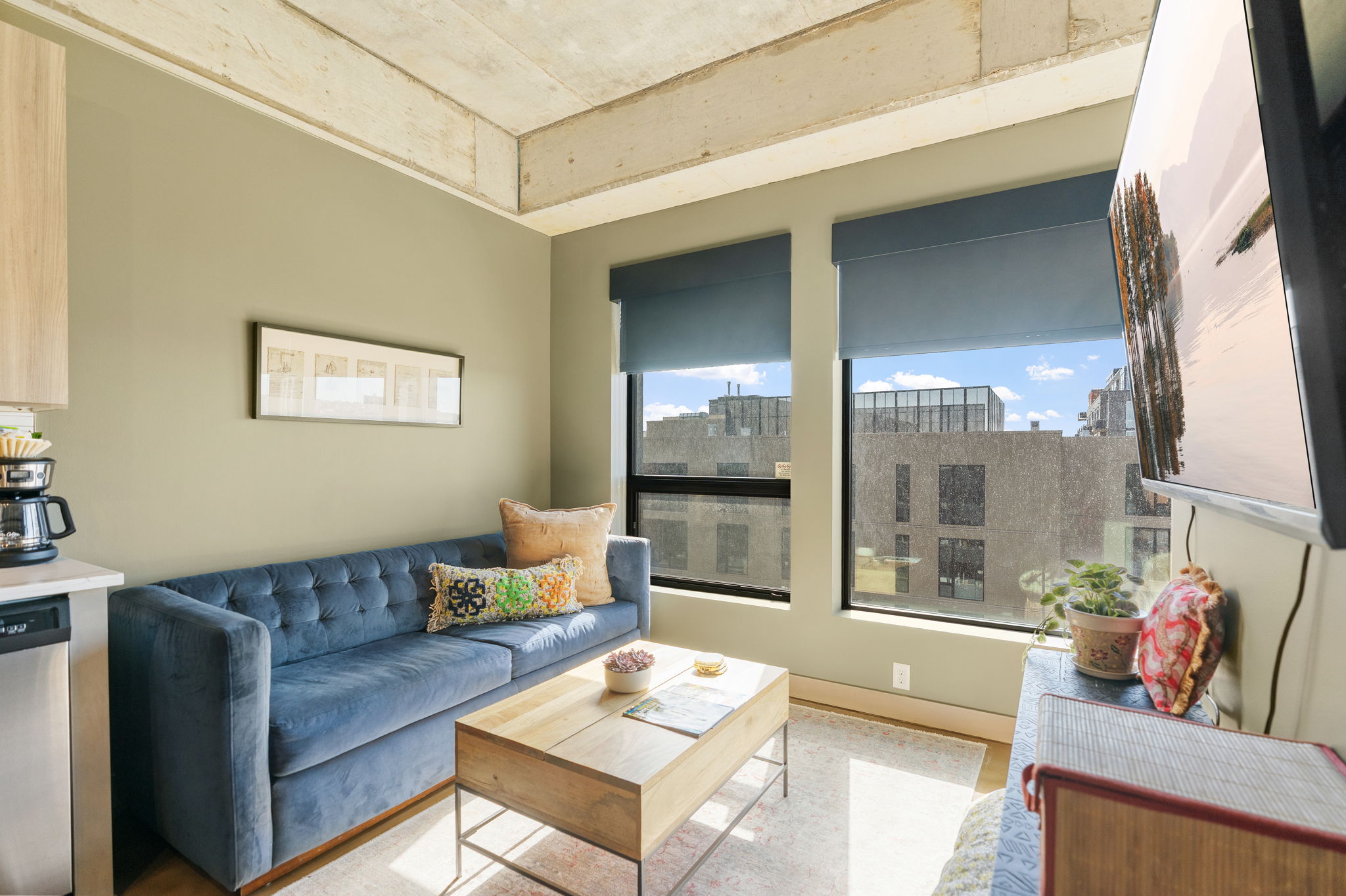 Contemporary living room with a cozy blue sofa and urban views.