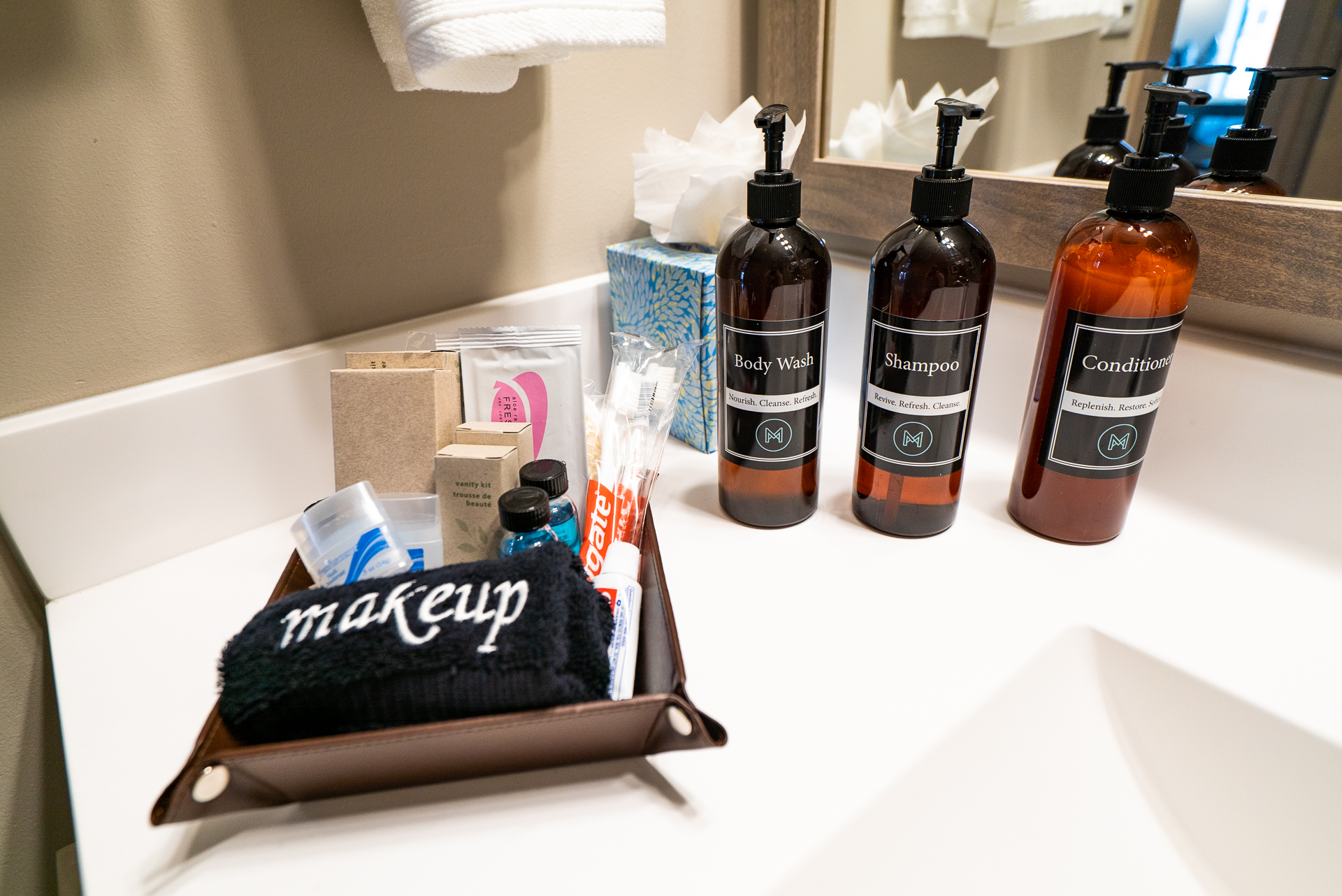 Neatly organized bathroom essentials, highlighting body wash, shampoo, and conditioner along with makeup supplies.