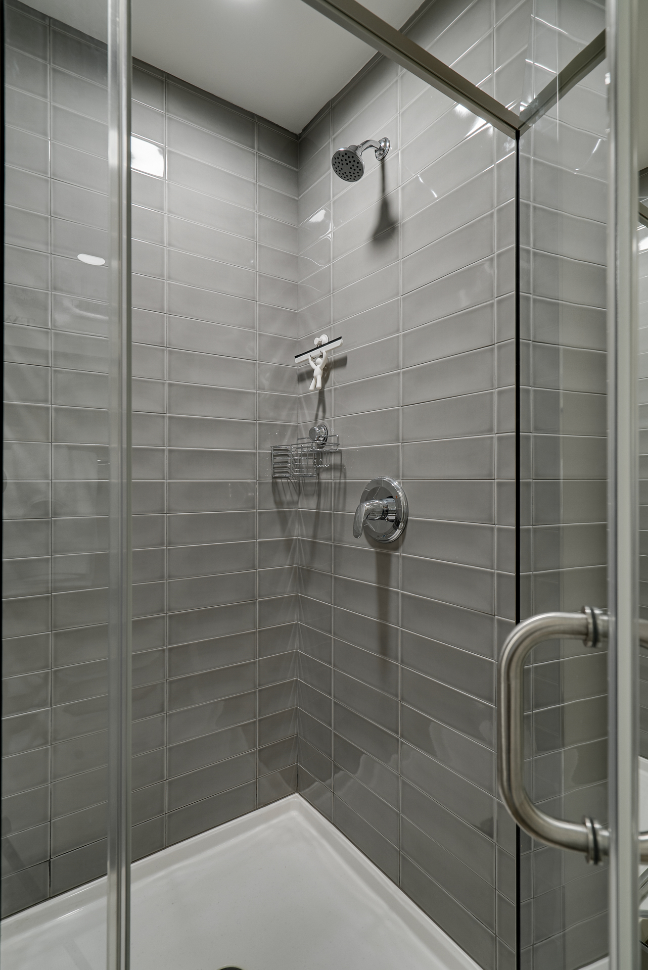 A sleek, modern shower enclosure with grey tiles and elegant fixtures.