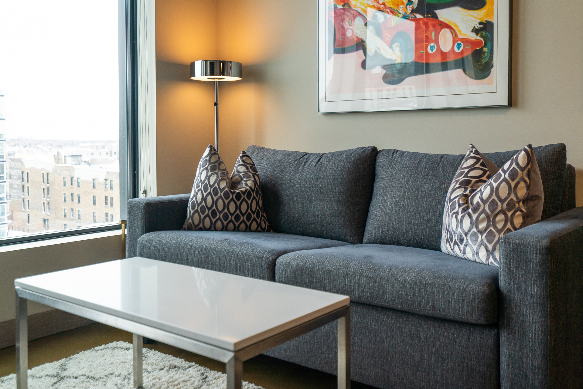 A cozy living room featuring a dark gray sofa with decorative pillows and a stylish coffee table.