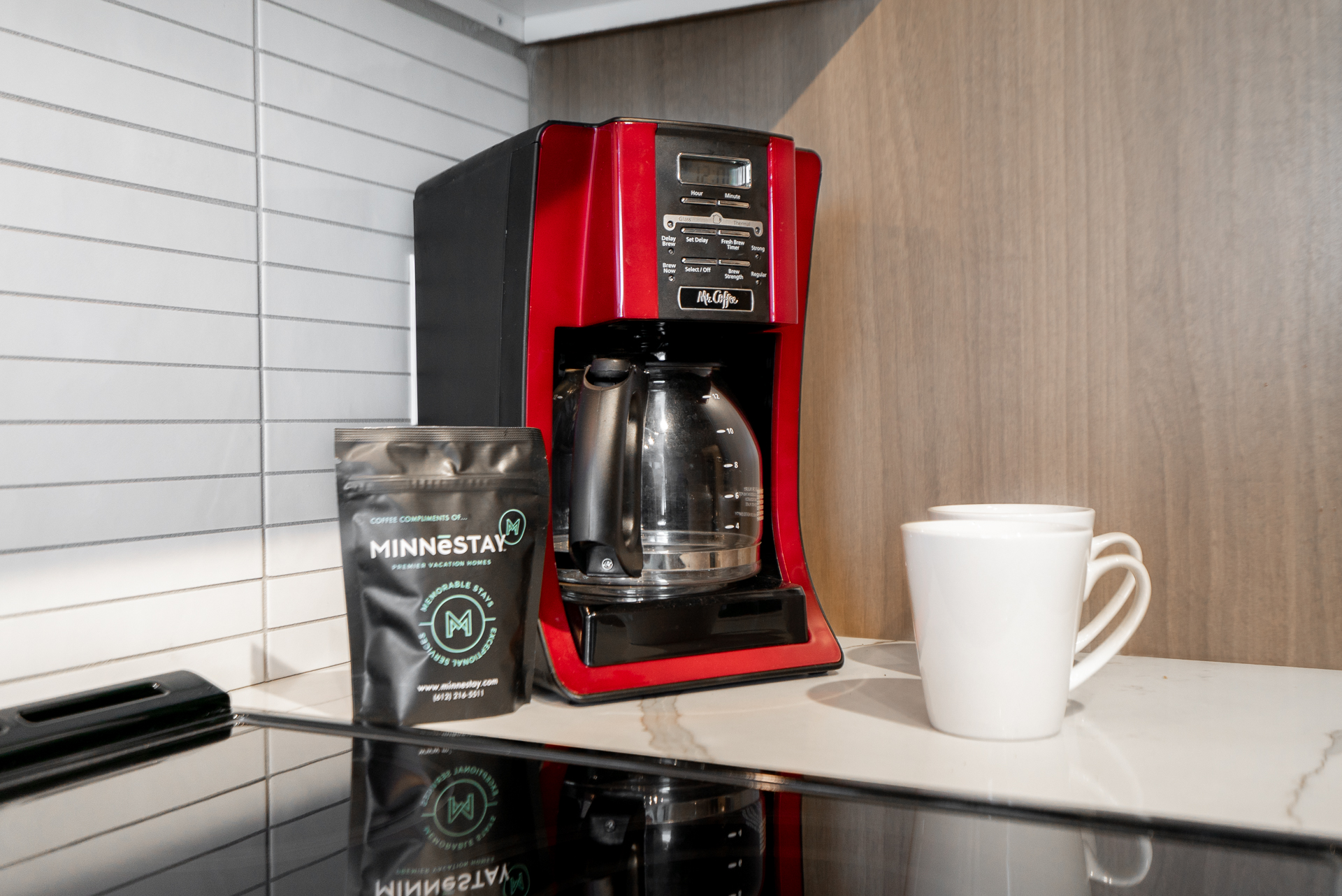 A cozy kitchen scene featuring a red coffee maker and coffee accessories.